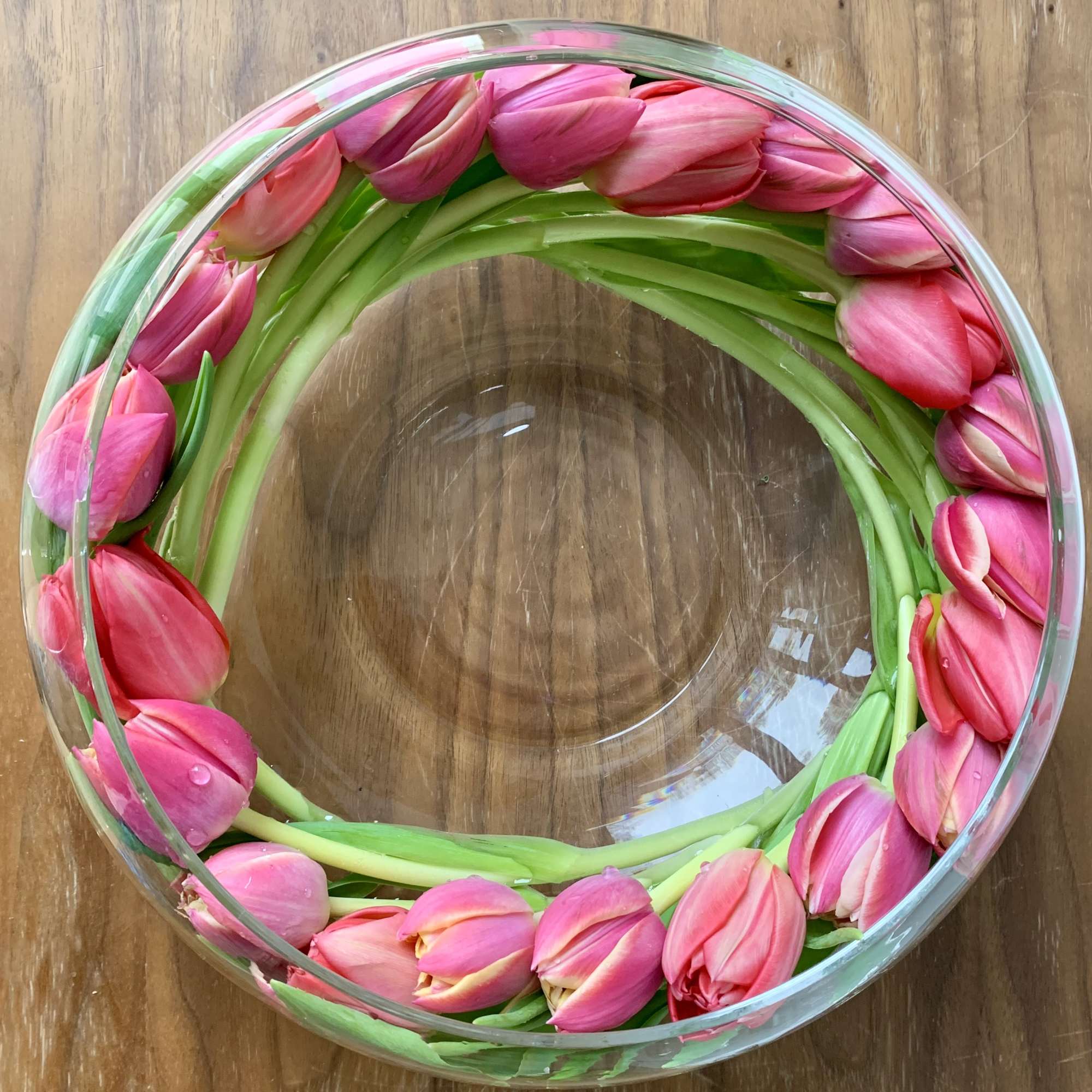 Modern arrangement of 20+ tulips in a shallow glass bowl selected by