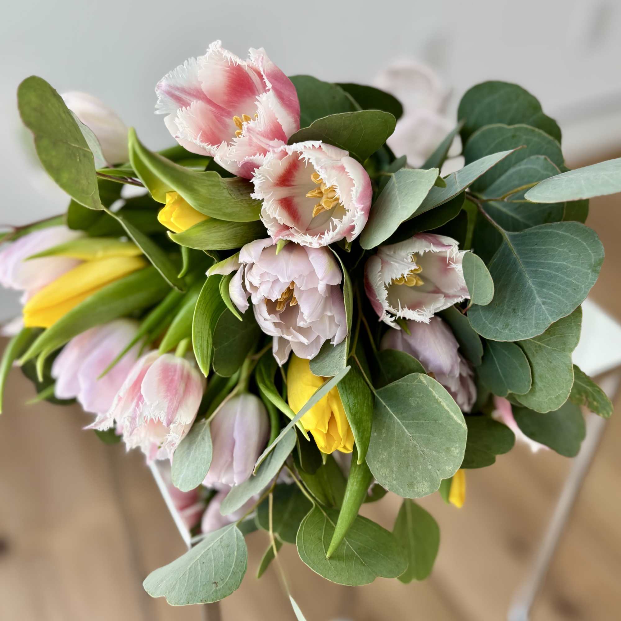 A bouquet of 25 premium tulips with greenery (no vase included), hand-tied