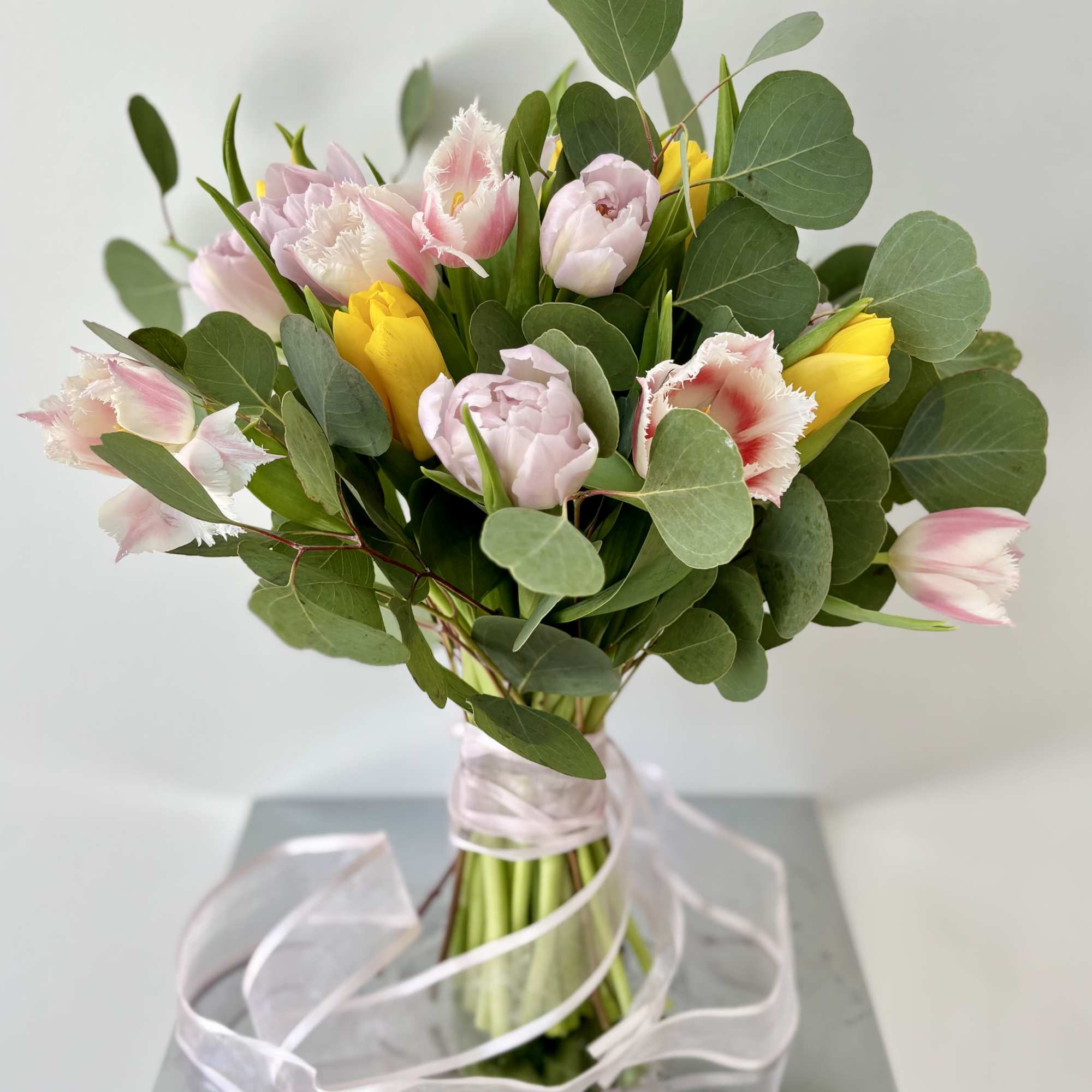A bouquet of 25 premium tulips with greenery (no vase included), hand-tied