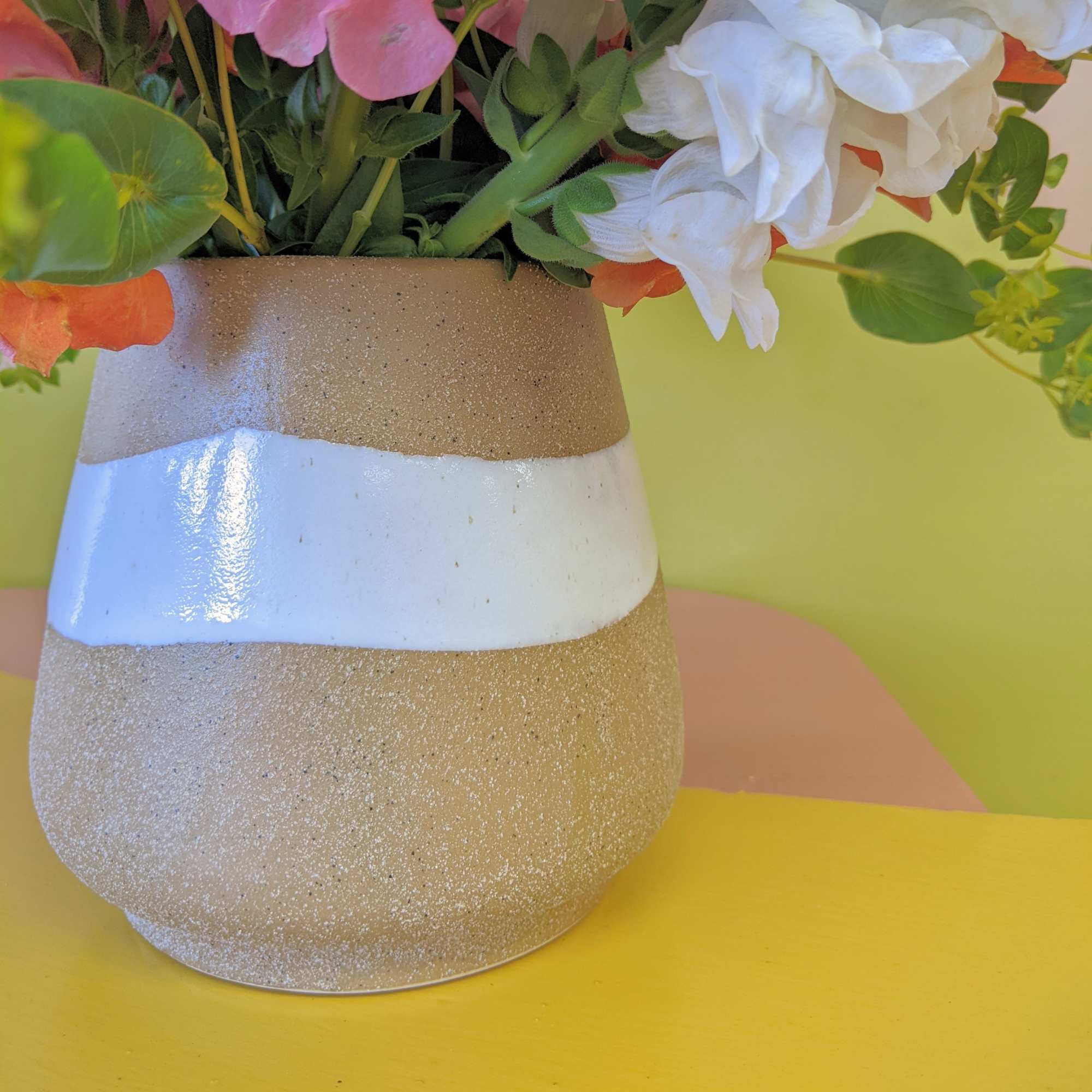 An array of snapdragons in a earthy vase is perfect for anyone