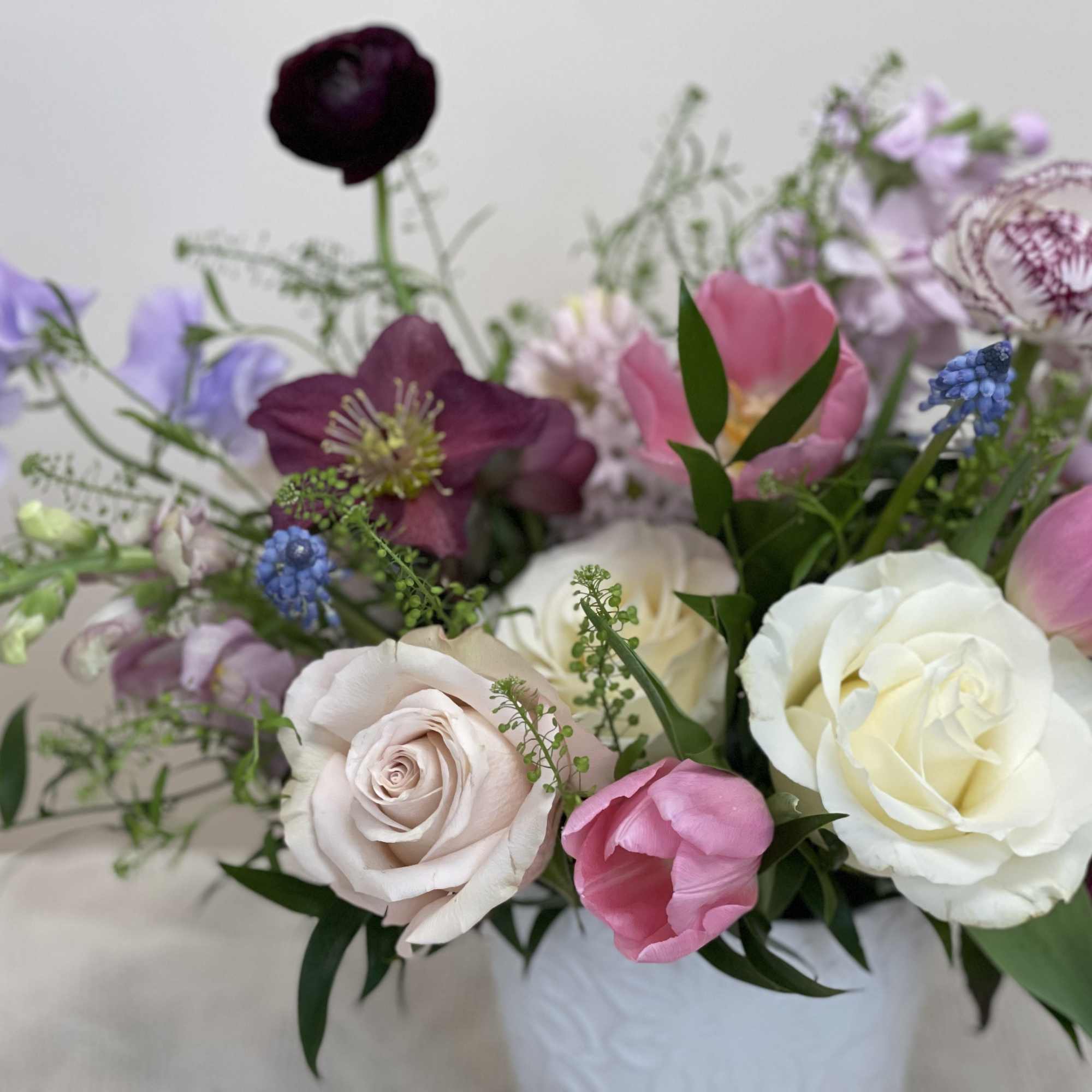 An arrangement full of fragrant spring blooms in a low vase, with