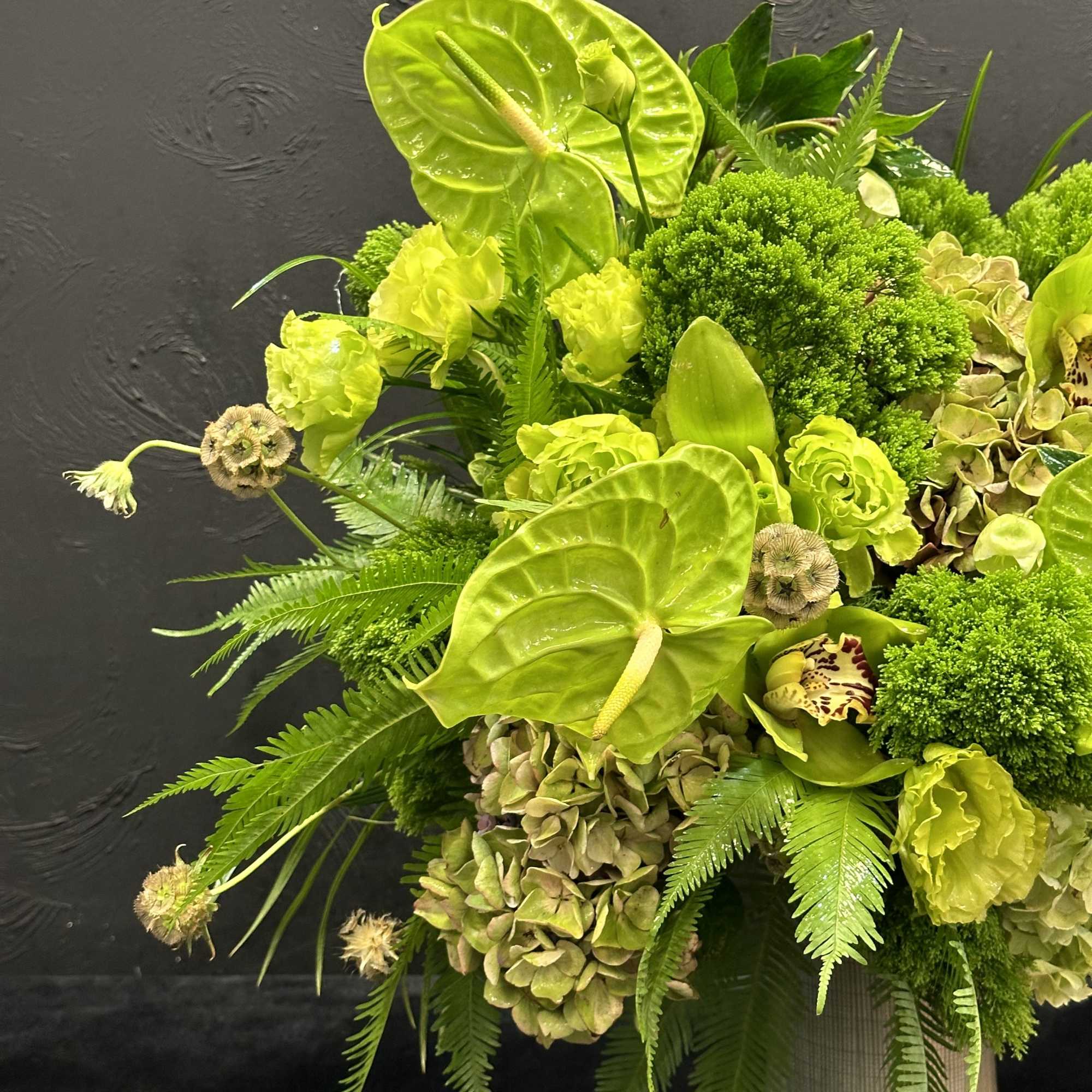 This striking arrangement features a vibrant mix of green flowers, creating a
