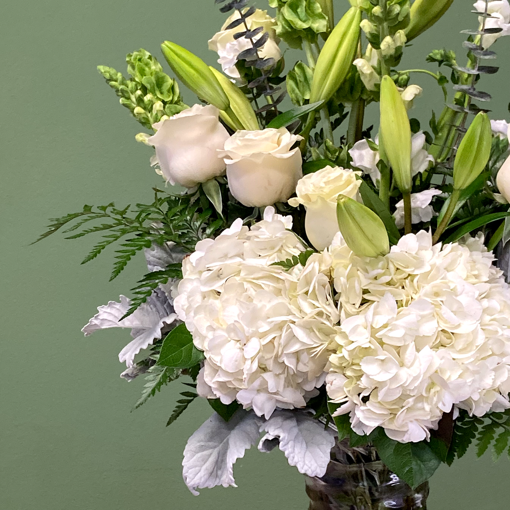 A serene mixed arrangement that showcases a white and green palette, featuring