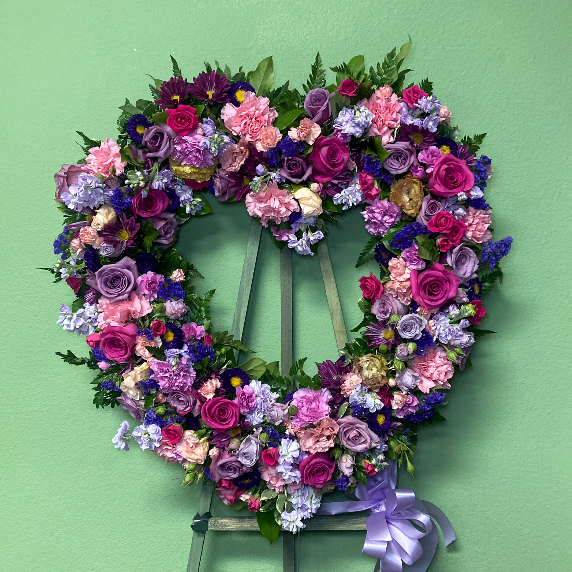 Lavender Tribute is a tranquil Standing Wreath of flowers that arrives delivered