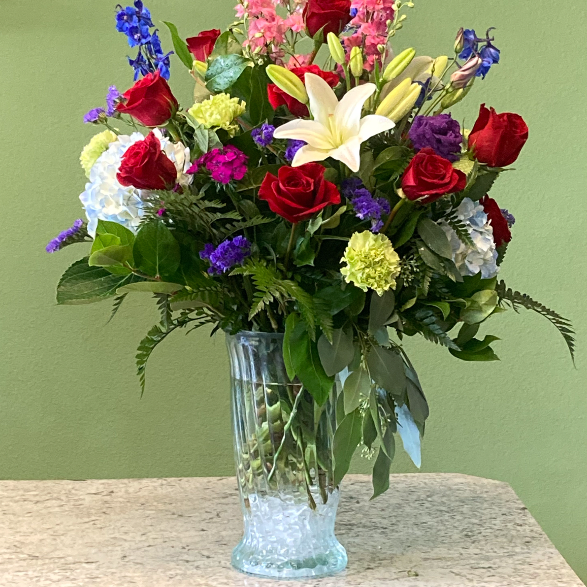 A beautiful arrangement, featuring one dozen (12) premium red roses, blended with