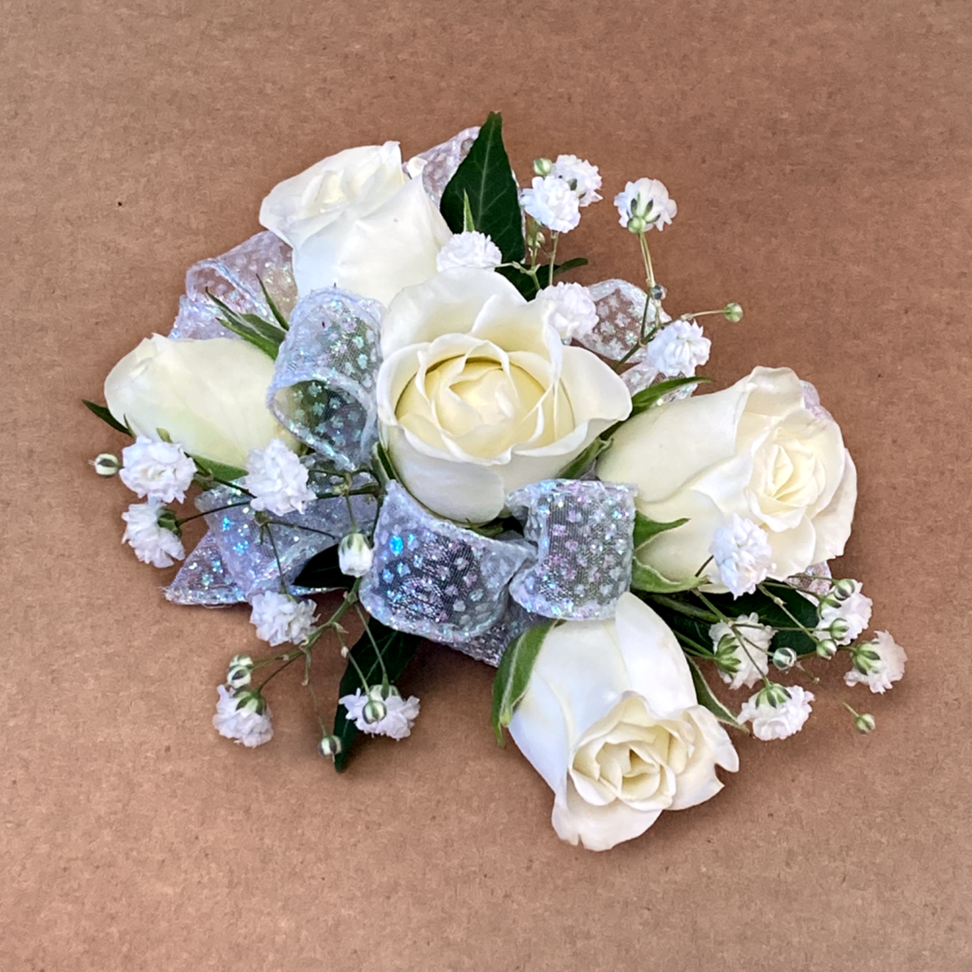 Our wristlet corsage features 5 spray-roses, baby&#039;s breath and freshly-cut greens. Accented