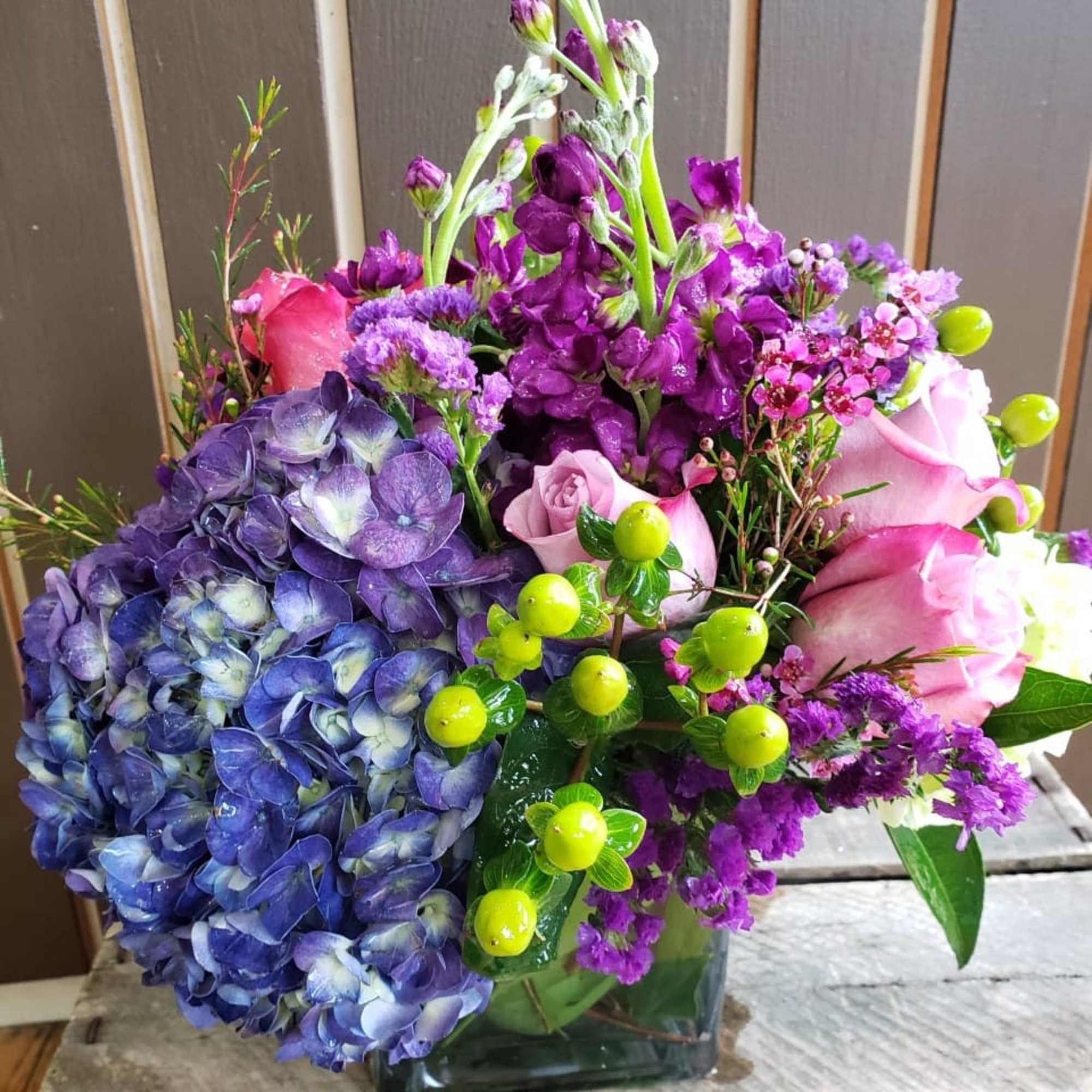 a mixes flowers vase arrangement  such a , purple hydrangeas from