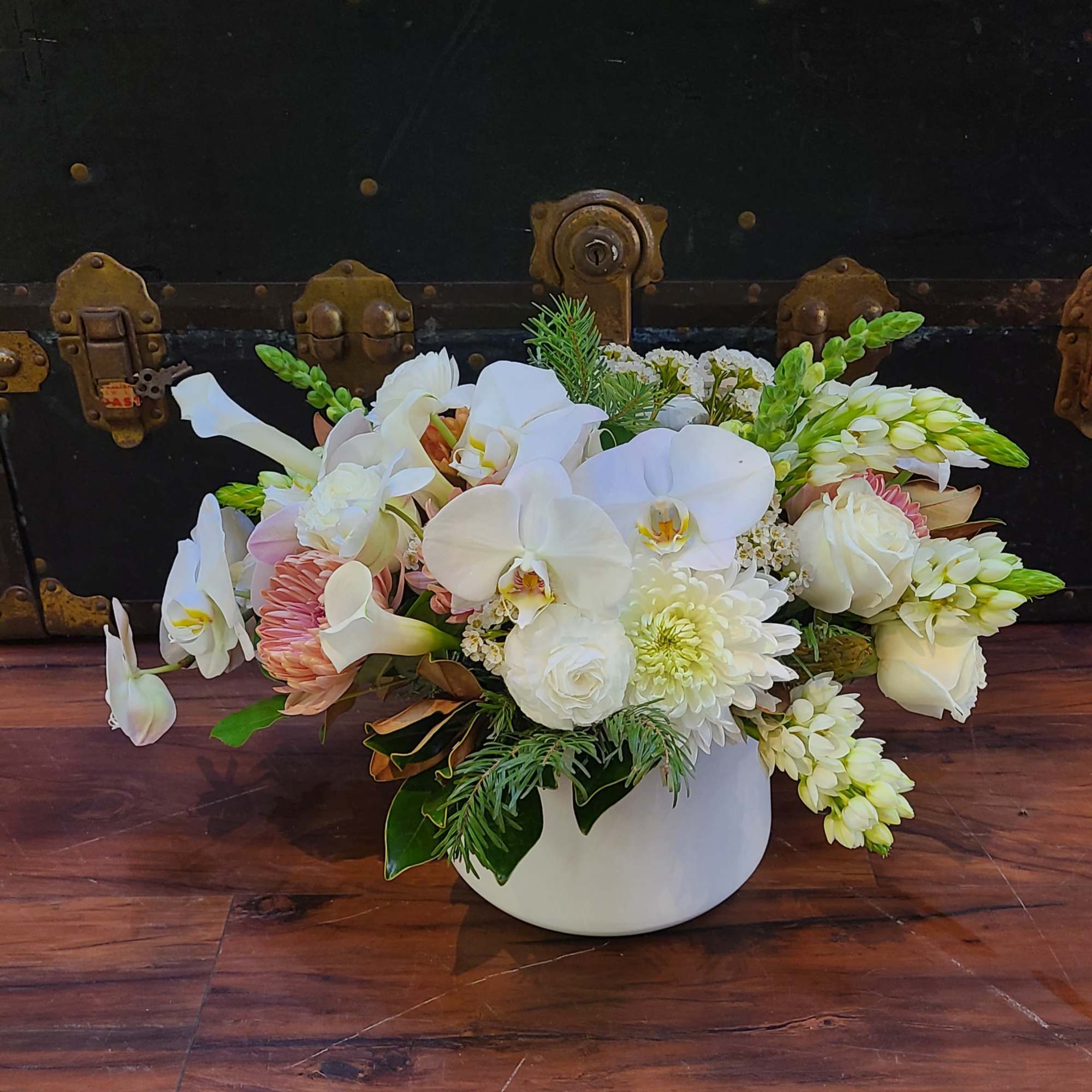 This design is full of winter greens and premium blooms that will