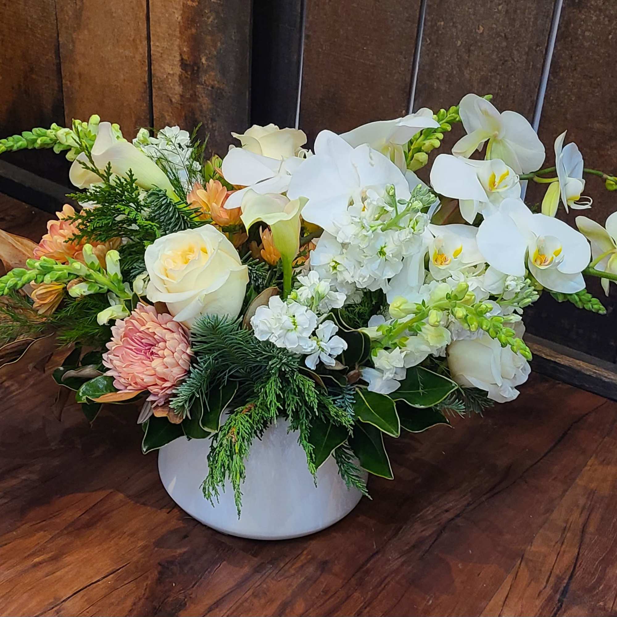 This design is full of winter greens and premium blooms that will