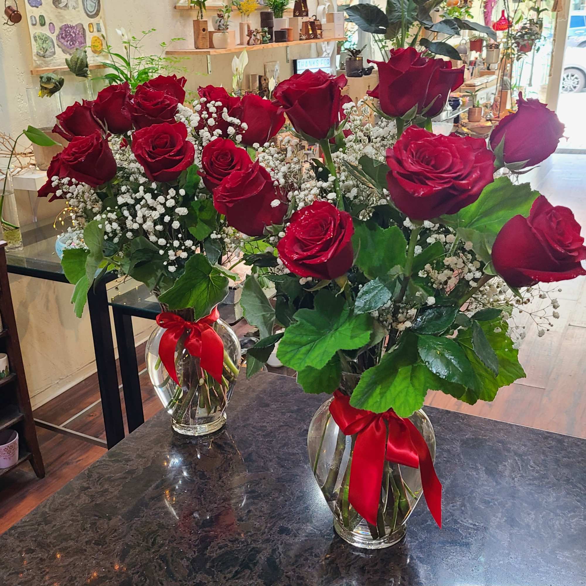 A dozen red roses, designed with babies breath and mixed foliage arranged