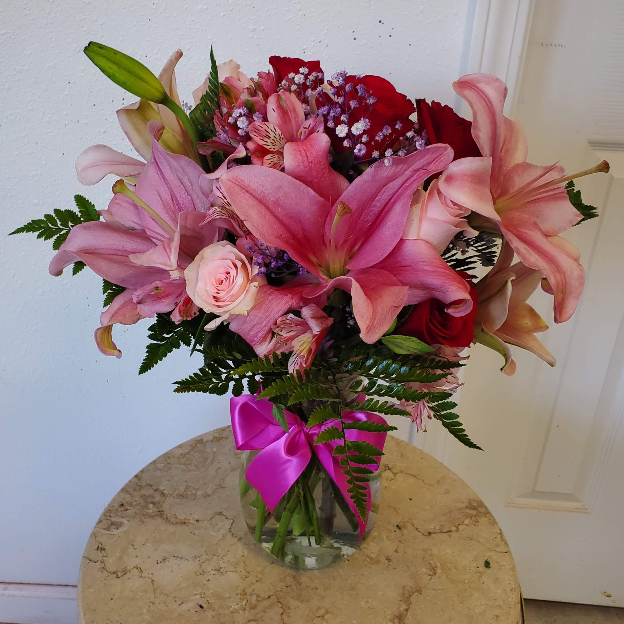 Crystal vase with an elegant arrangement of red &amp; pink roses, stems