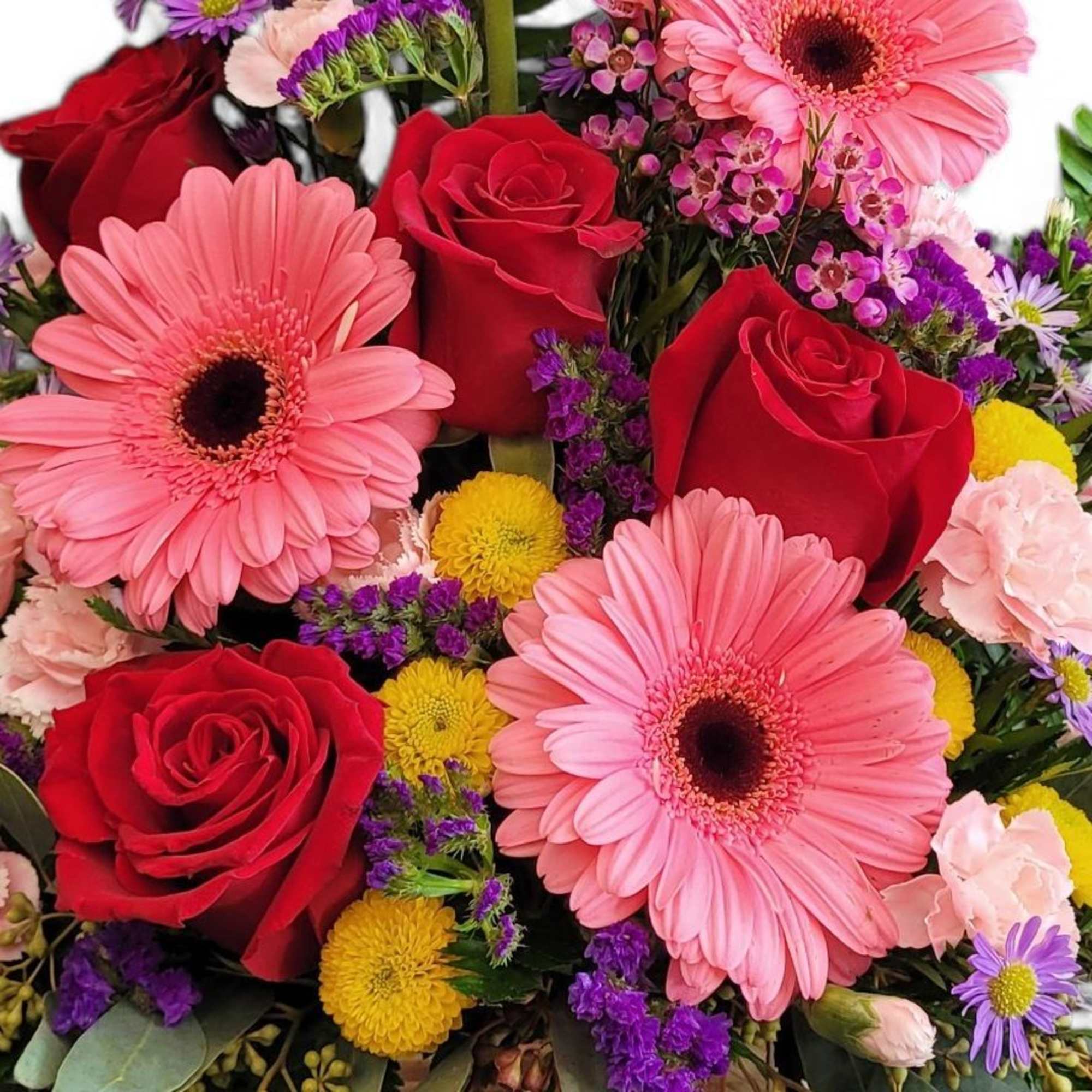 A beautiful arrangement of flowers in a rustic wooden cube overflowing with