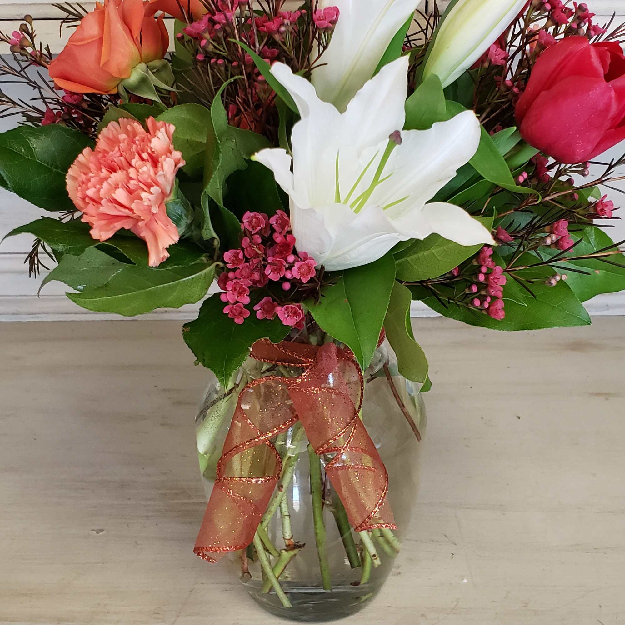 Vibrant orange spray roses, with cranberry colored waxflower, coral carnations and just Vibrant orange spray roses, with cranberry colored waxflower, coral carnations and just