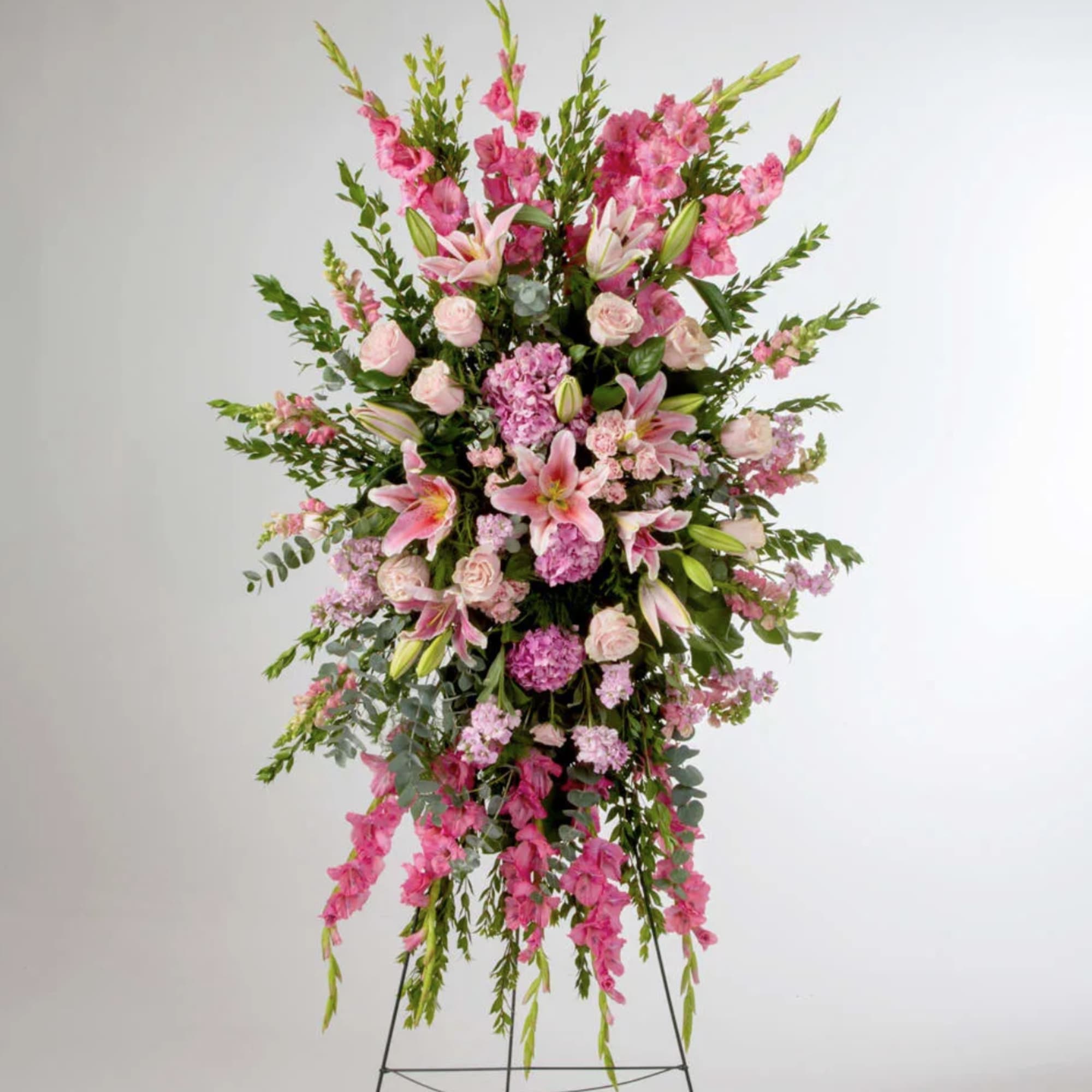 Pink roses, lilies, and more come together for a blushing pink standing