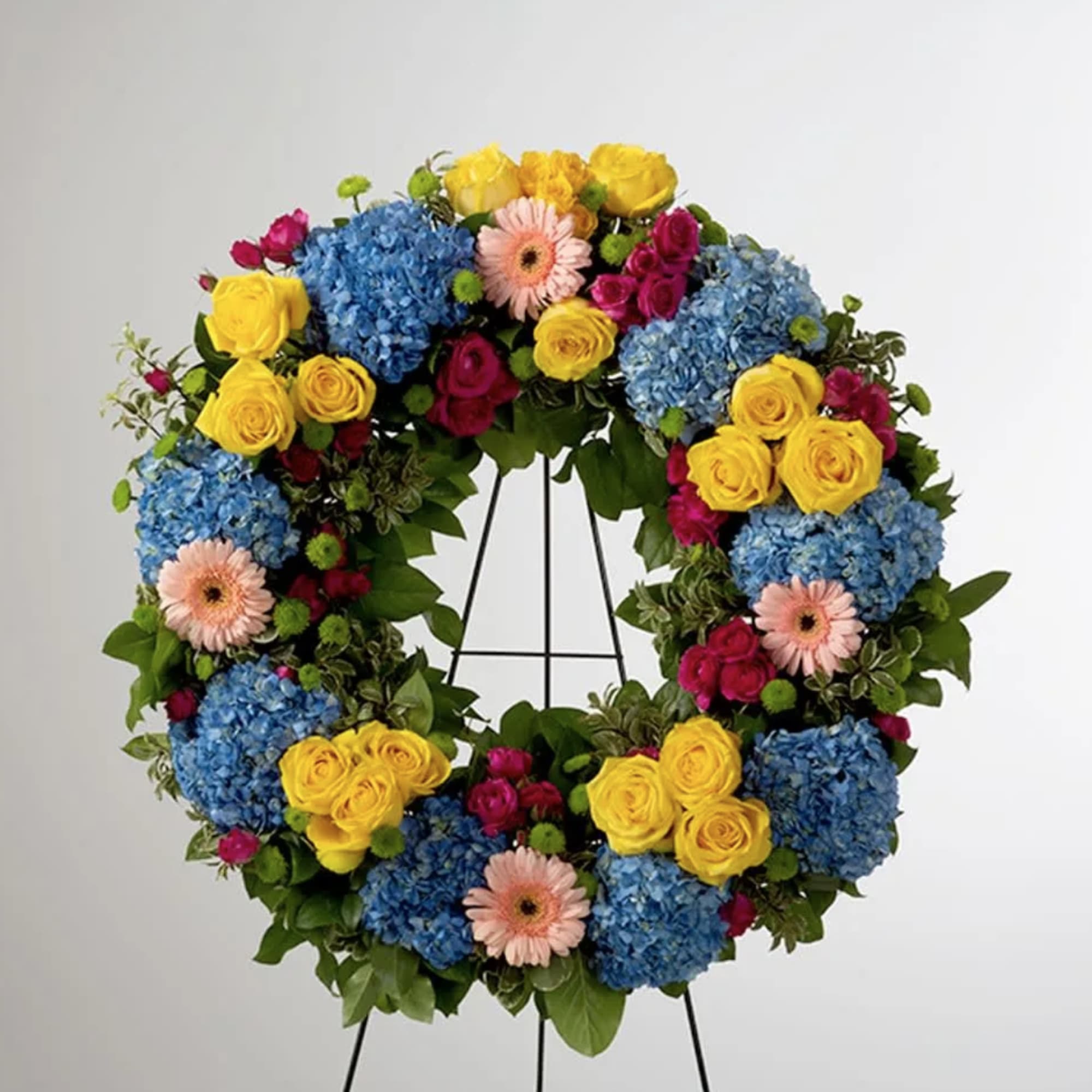 This colorful and bright wreath spray is representative of a life lived