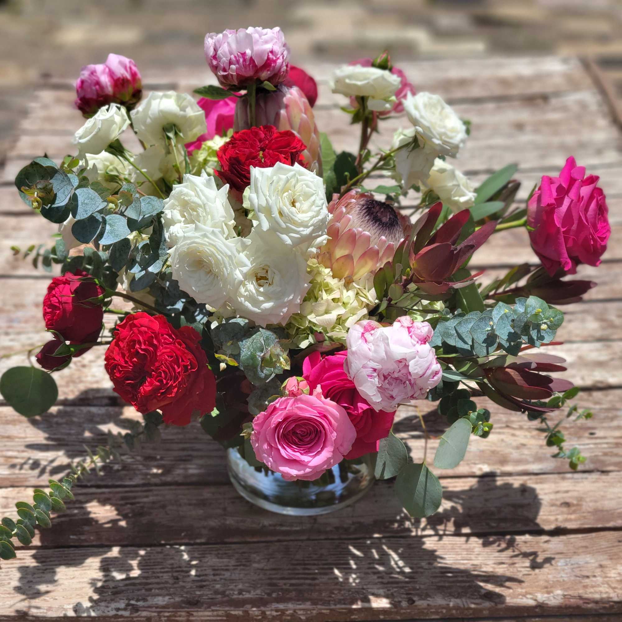 Lush composition in a tonal palette of reds, pinks and whites. Accented