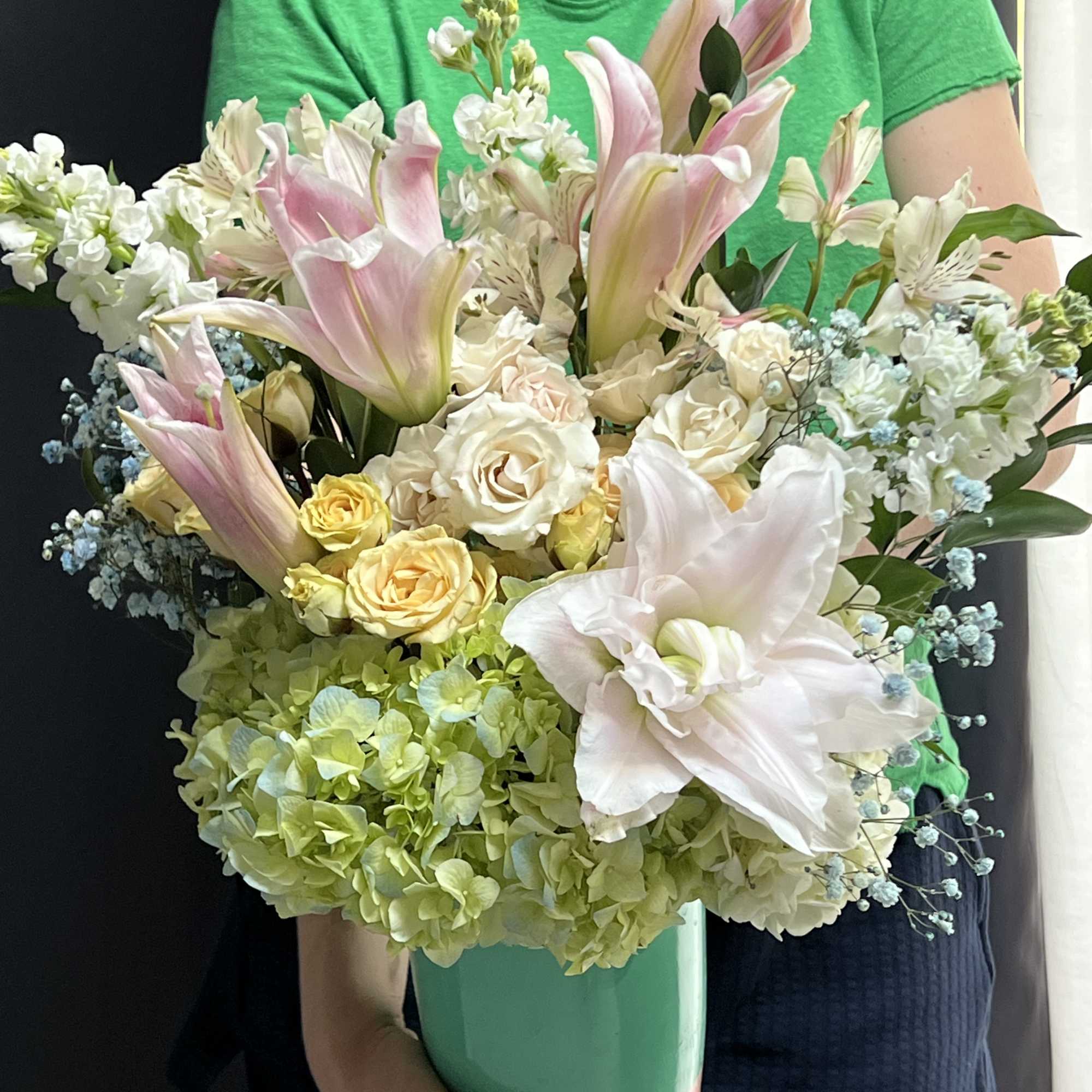 A bouquet composed of white roses, white lilies, blue hydrangeas, and lush A bouquet composed of white roses, white lilies, blue hydrangeas, and lush