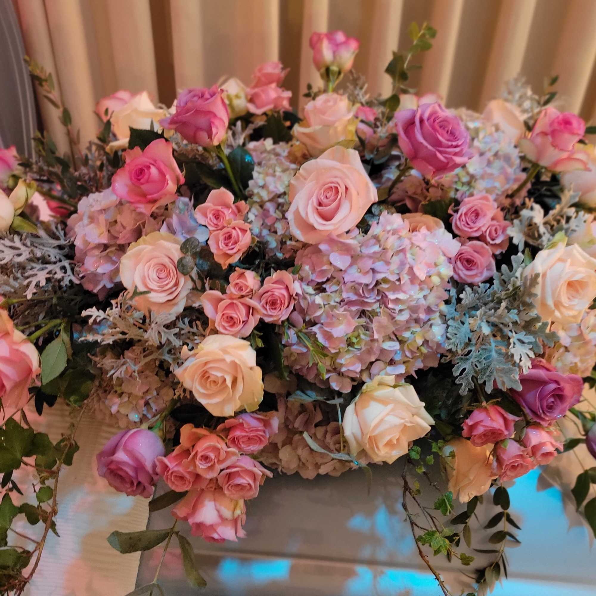 Lush casket cover in shades of pinks and lavender