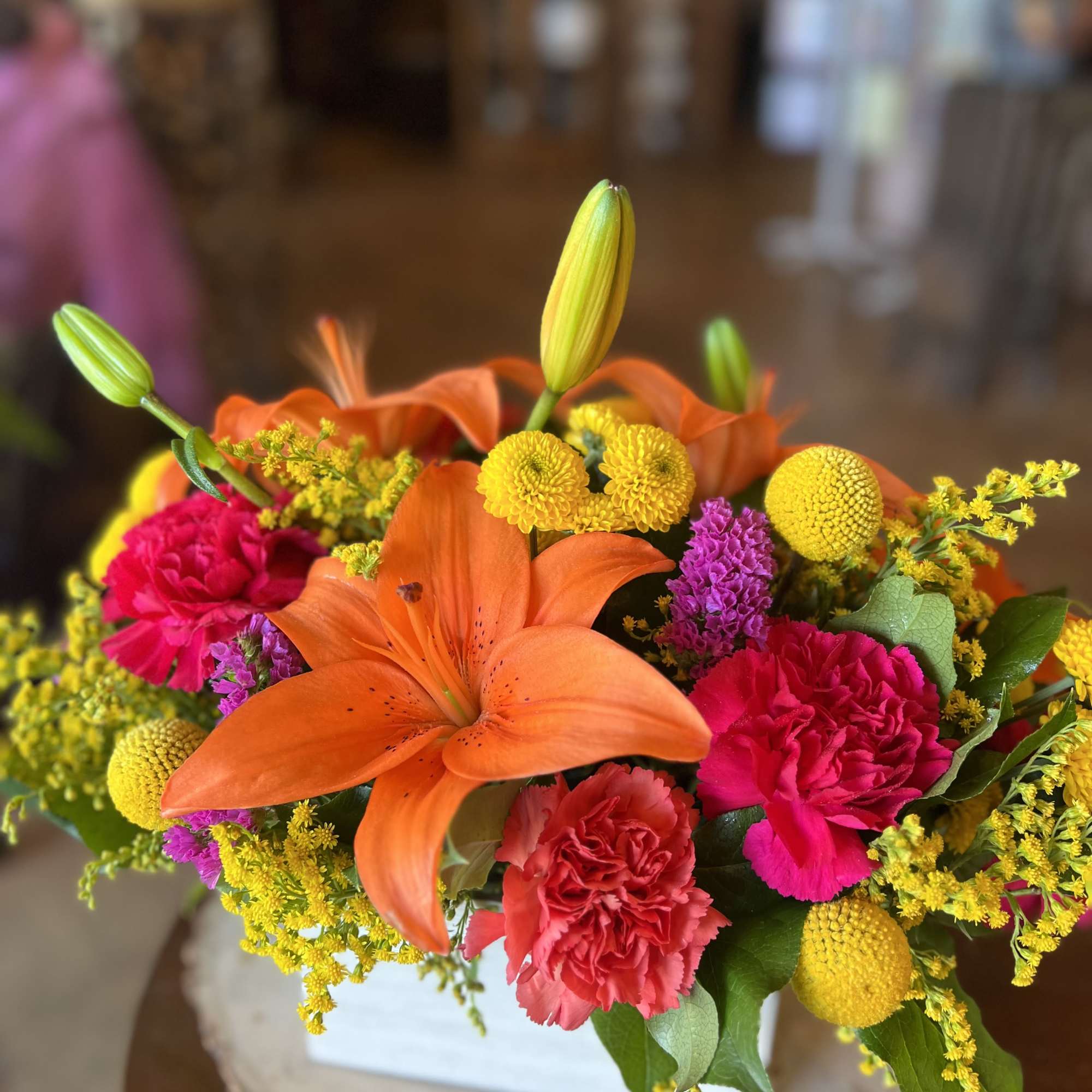 This bold, bright, and fiery boxed arrangement contains orange day lilies, solidago