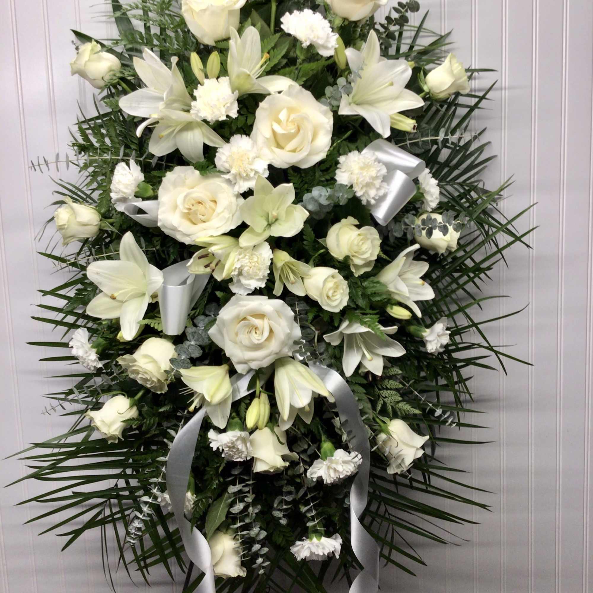Beautifully simple this lovely spray of white roses lilies and carnations decorated