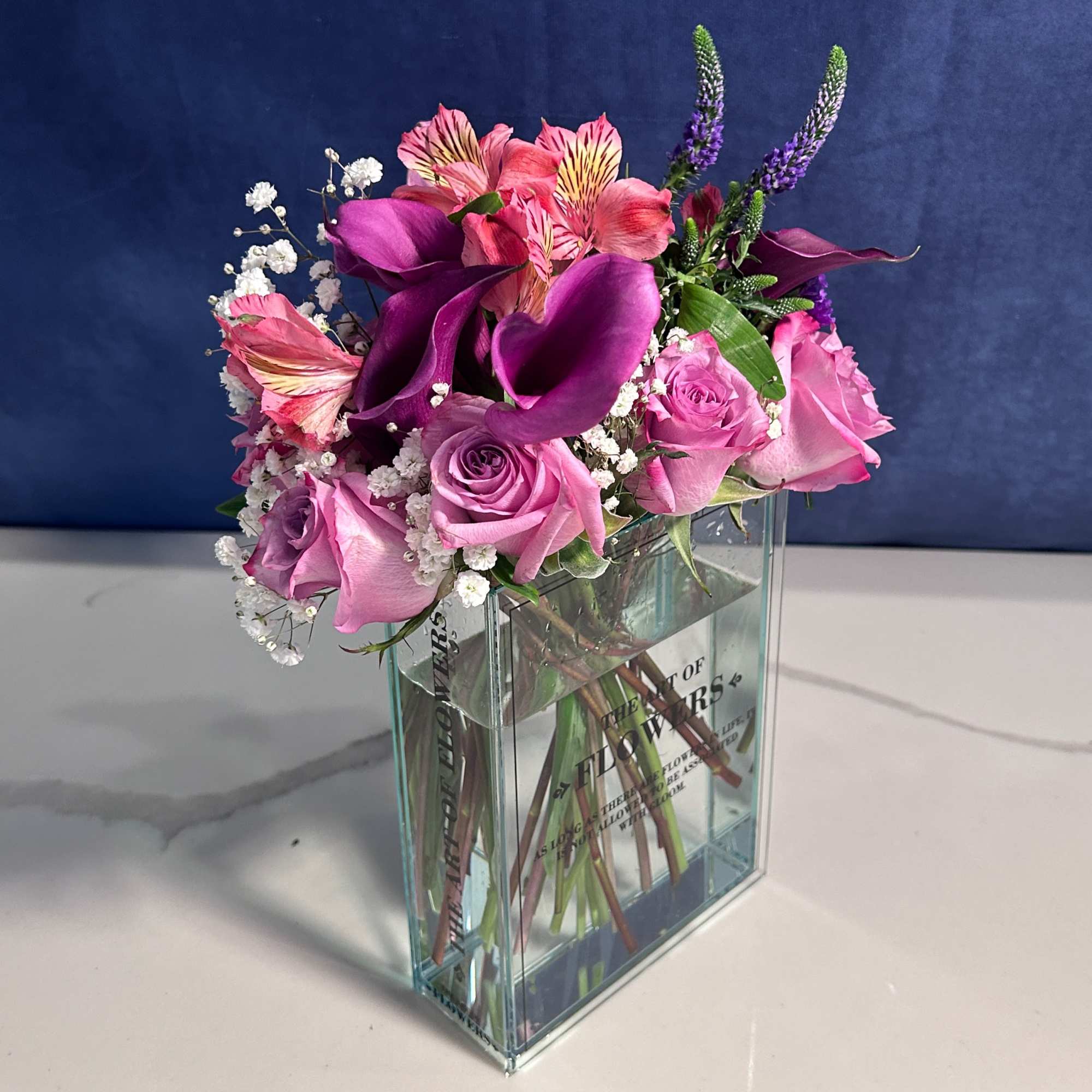 Purple roses and mini calla lilies framed with whites and pinks in Purple roses and mini calla lilies framed with whites and pinks in