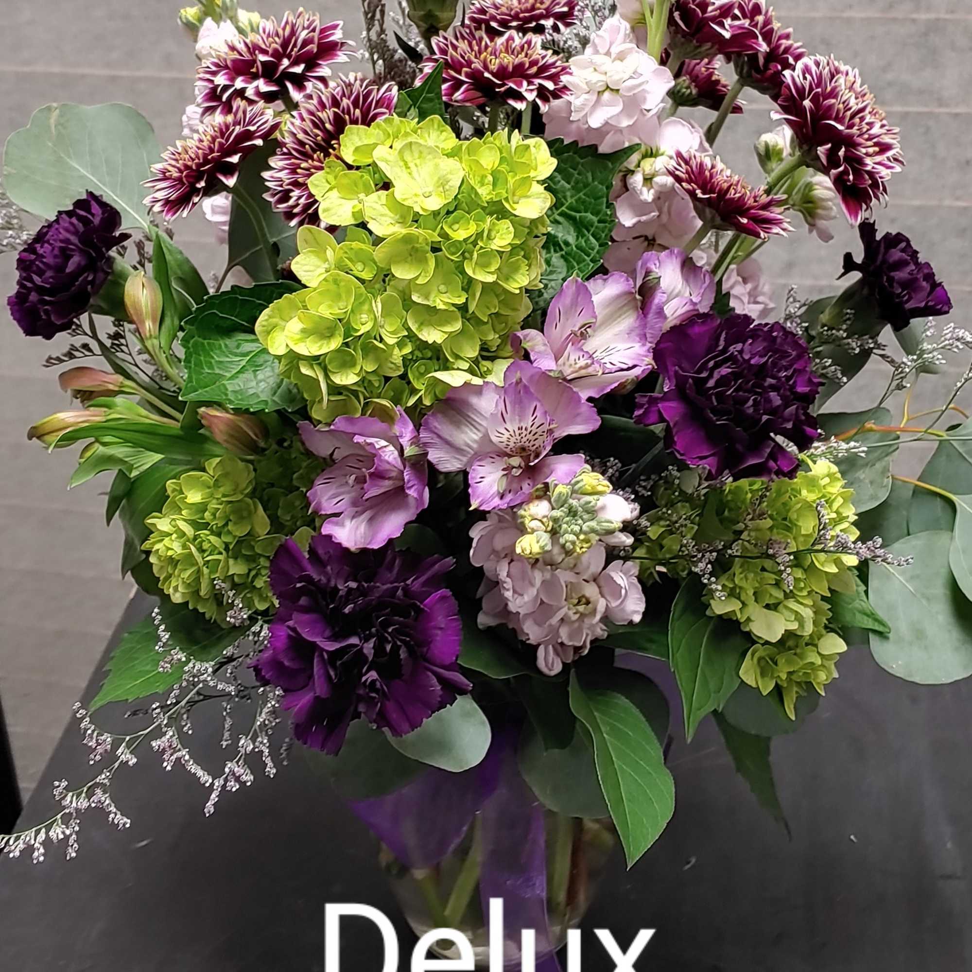 Poppin out of all the green is assortment of purple Moonshade carnations