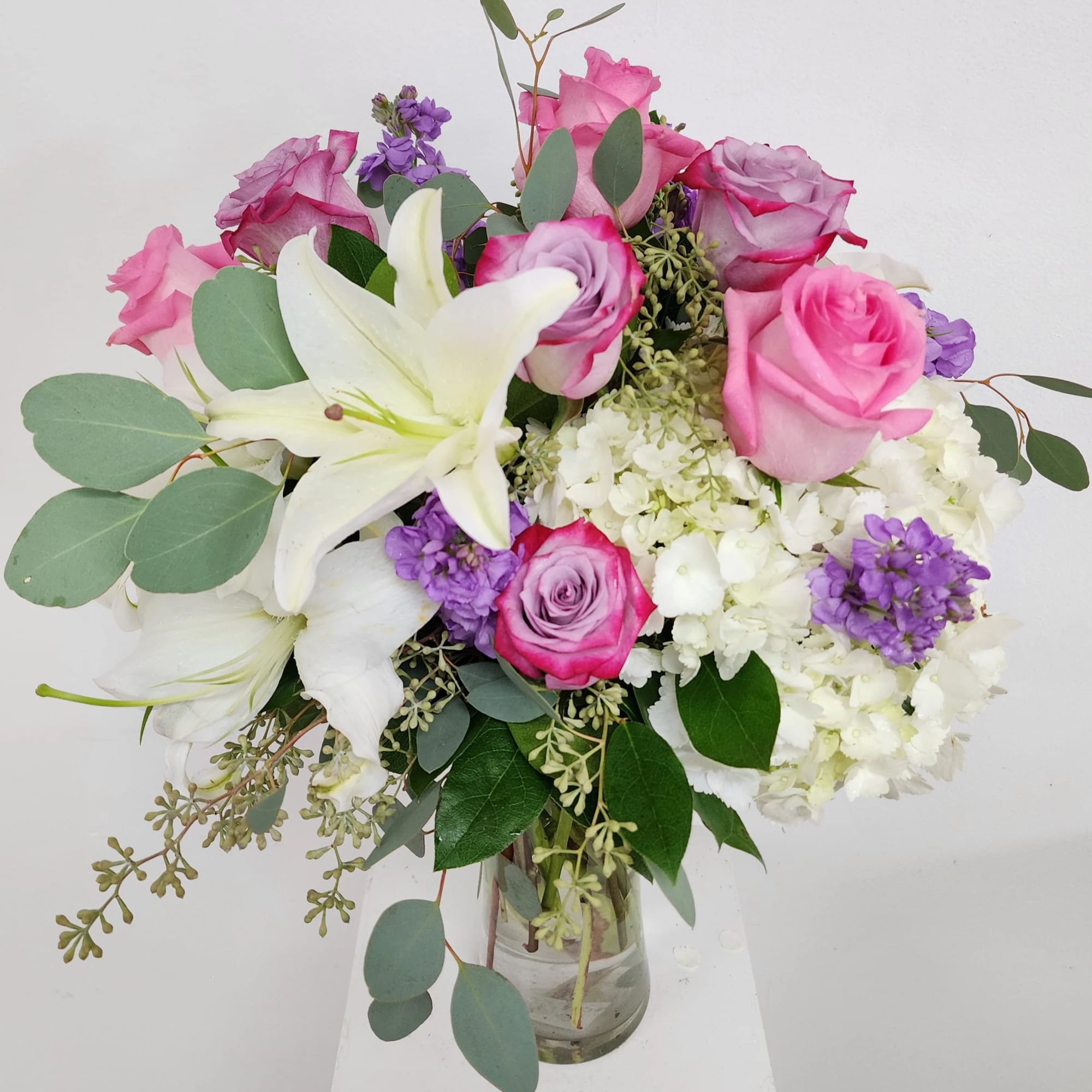 Hermosa or pink roses, lavender roses, lavender stock, hydrangea, wax and silver