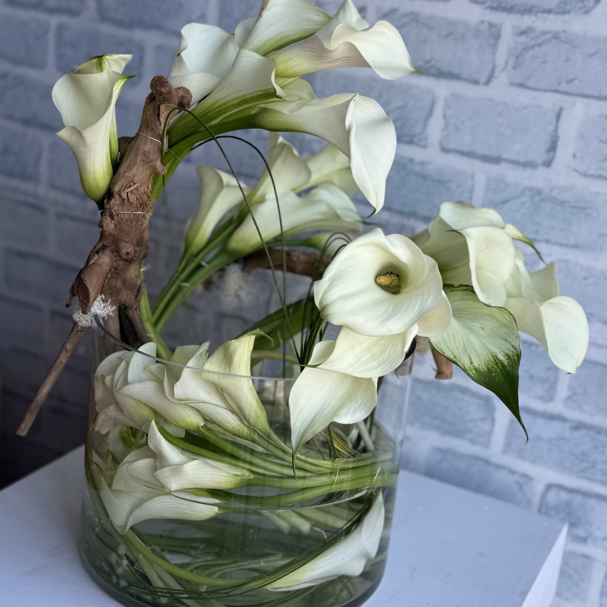 An exquisite display of 55 pristine ivory calla lilies, elegantly arranged in An exquisite display of 55 pristine ivory calla lilies, elegantly arranged in