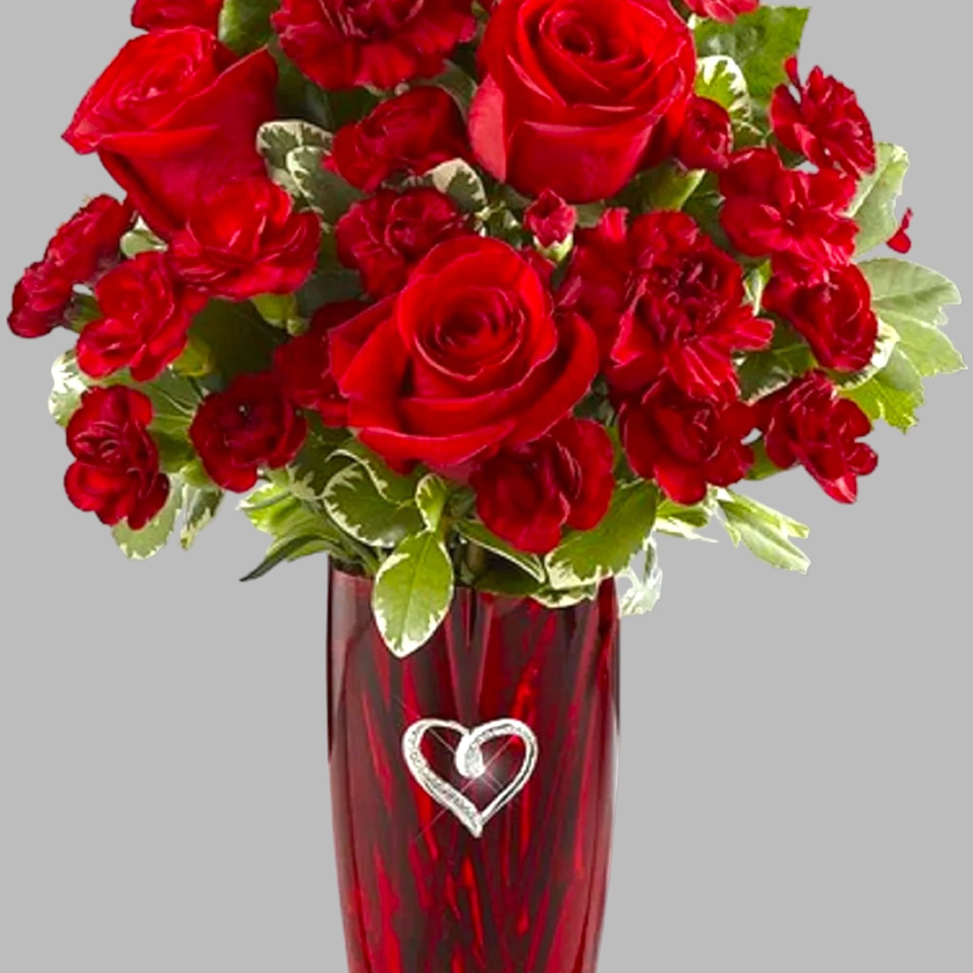 This vase includes a brilliant burst of red carnations and beautiful greens.