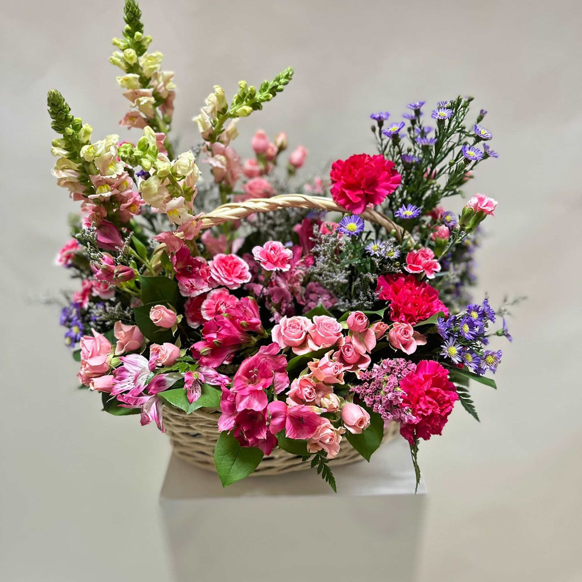 This arrangement is a vibrant and playful mix of pink, purple, and This arrangement is a vibrant and playful mix of pink, purple, and