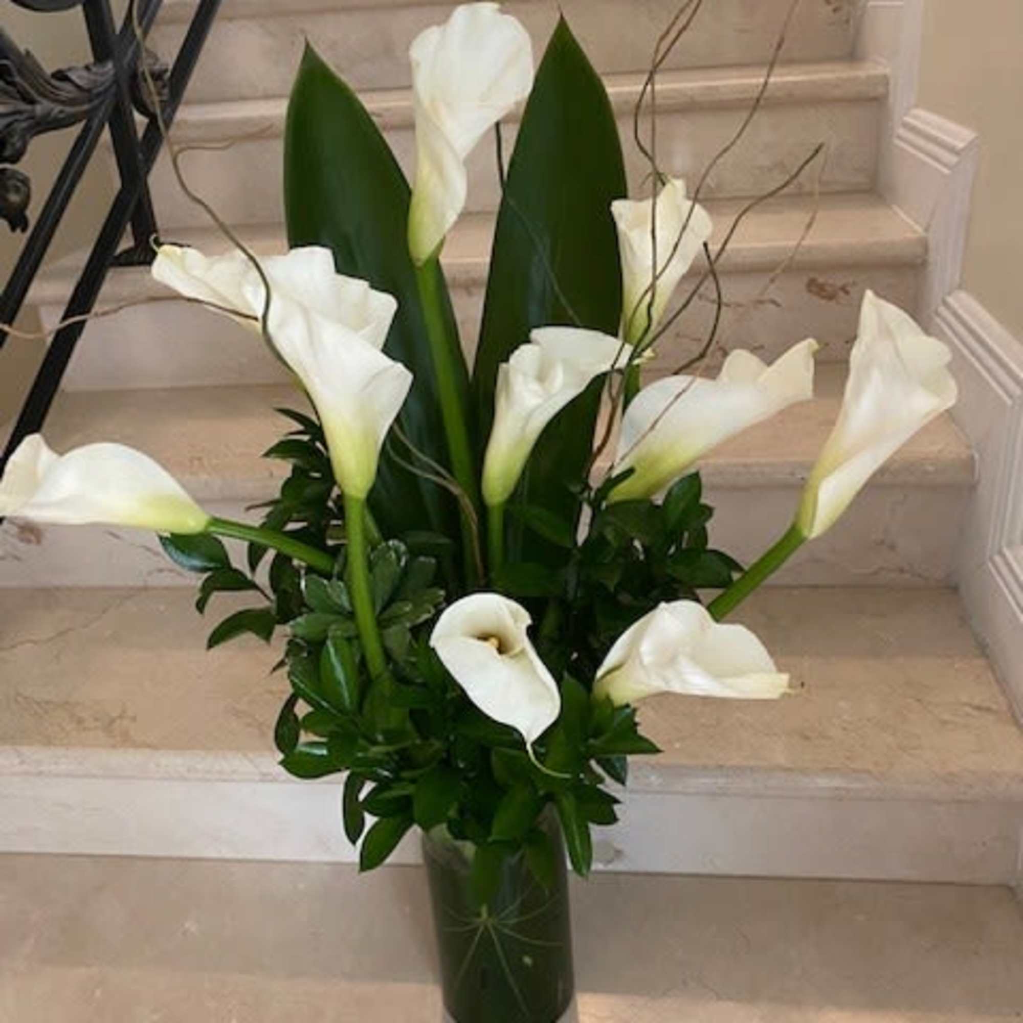 STANDARD has 10 White Callas, arranged in a vase.
DELUXE has 15 Callas