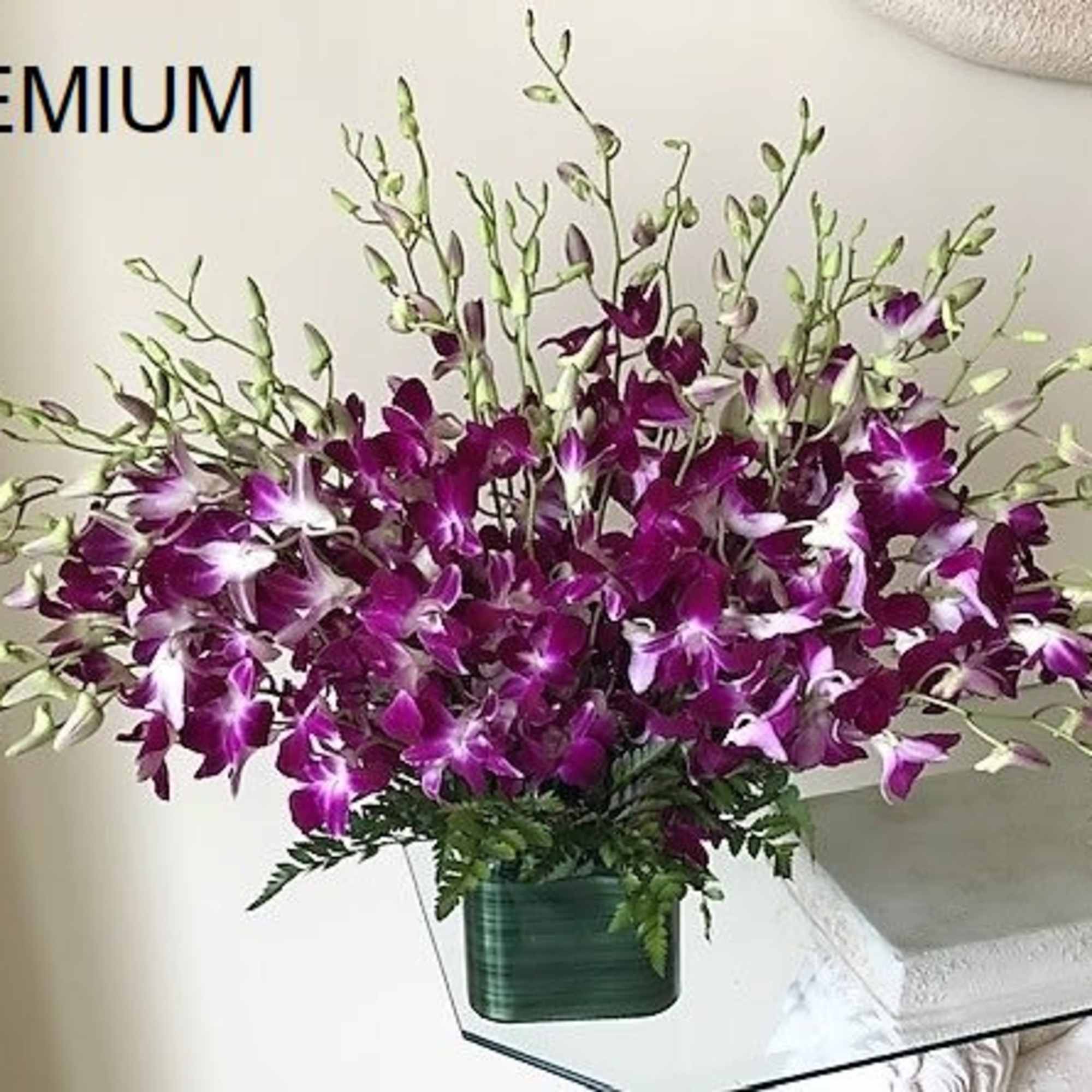 Purple Orchid flowers arranged in a glass cube. 
The quantity of flowers