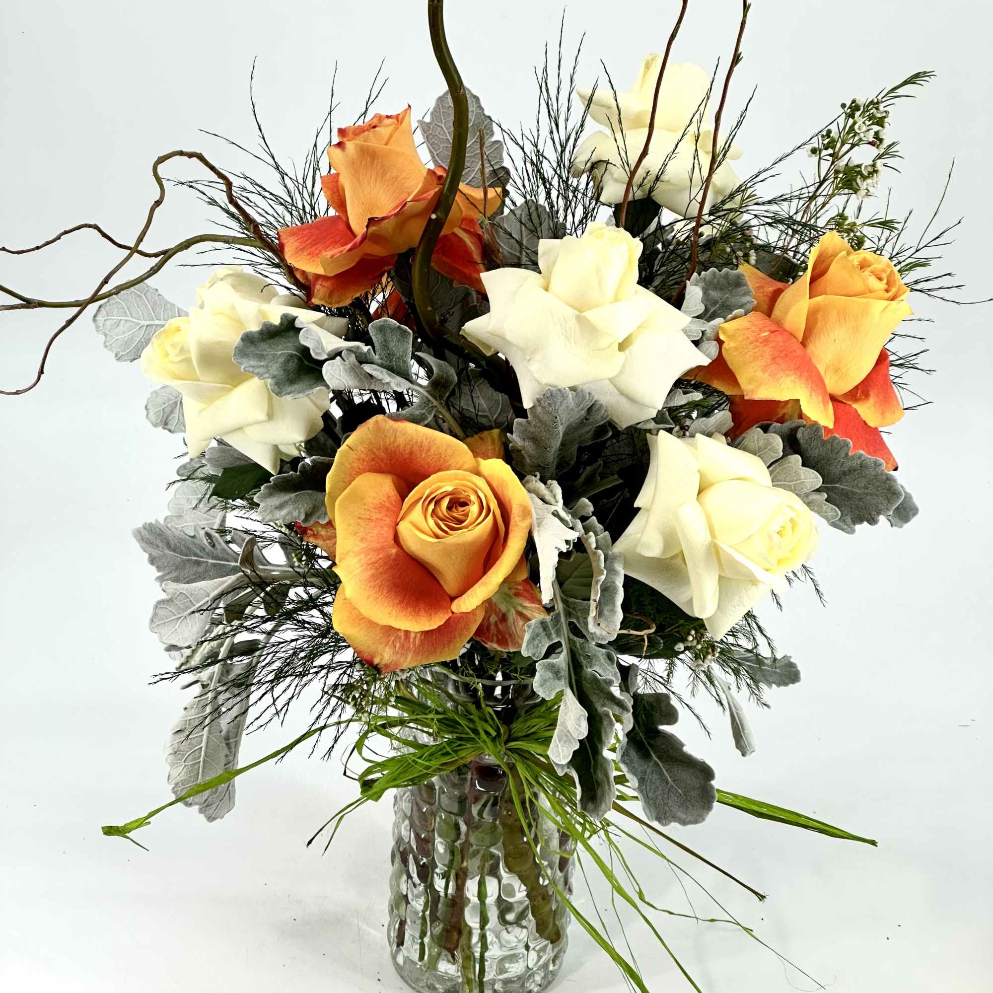 This arrangement includes pink roses, white roses, white spray roses, pink carnations