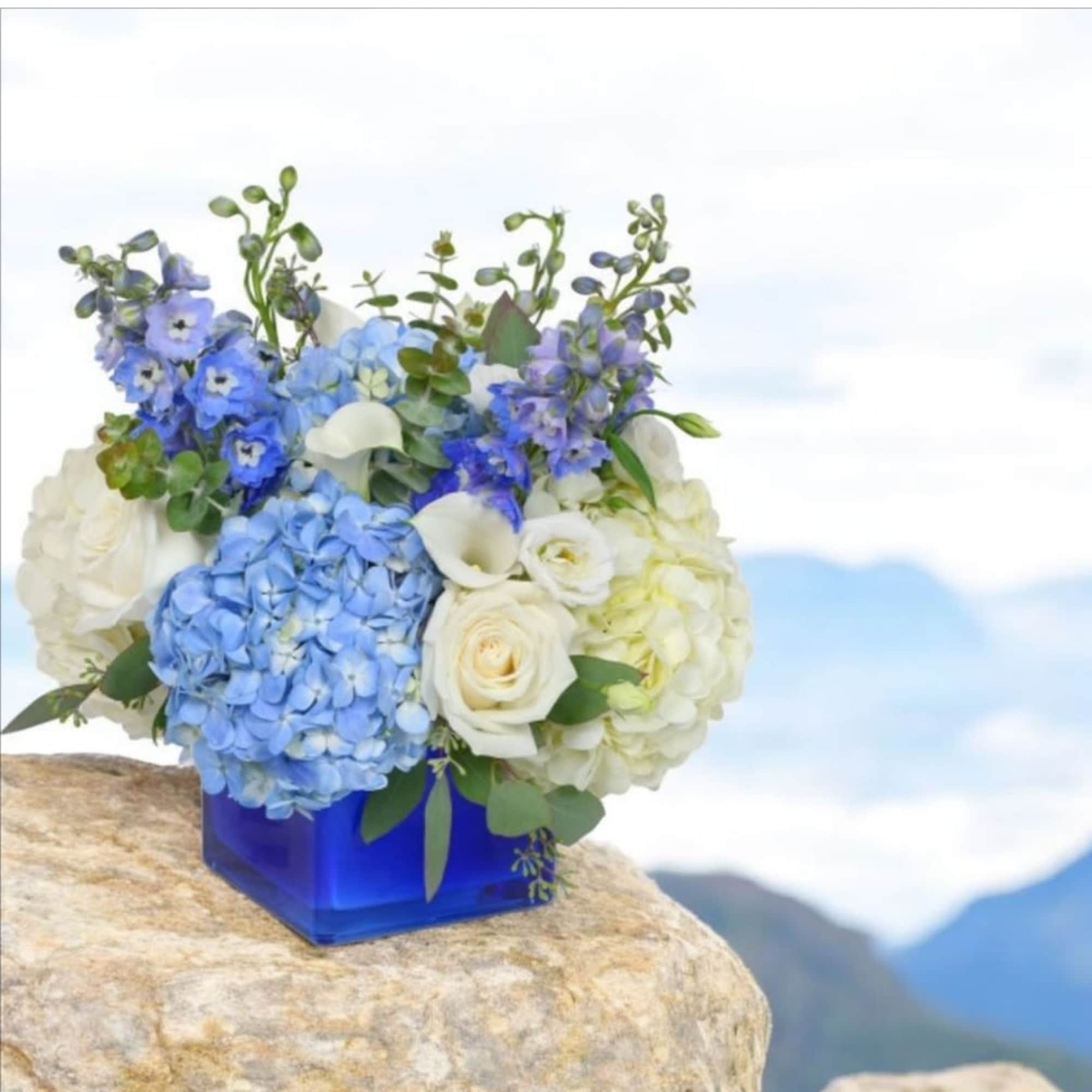 Blue delphinium, white roses, and calla lilies with lovely blue and white