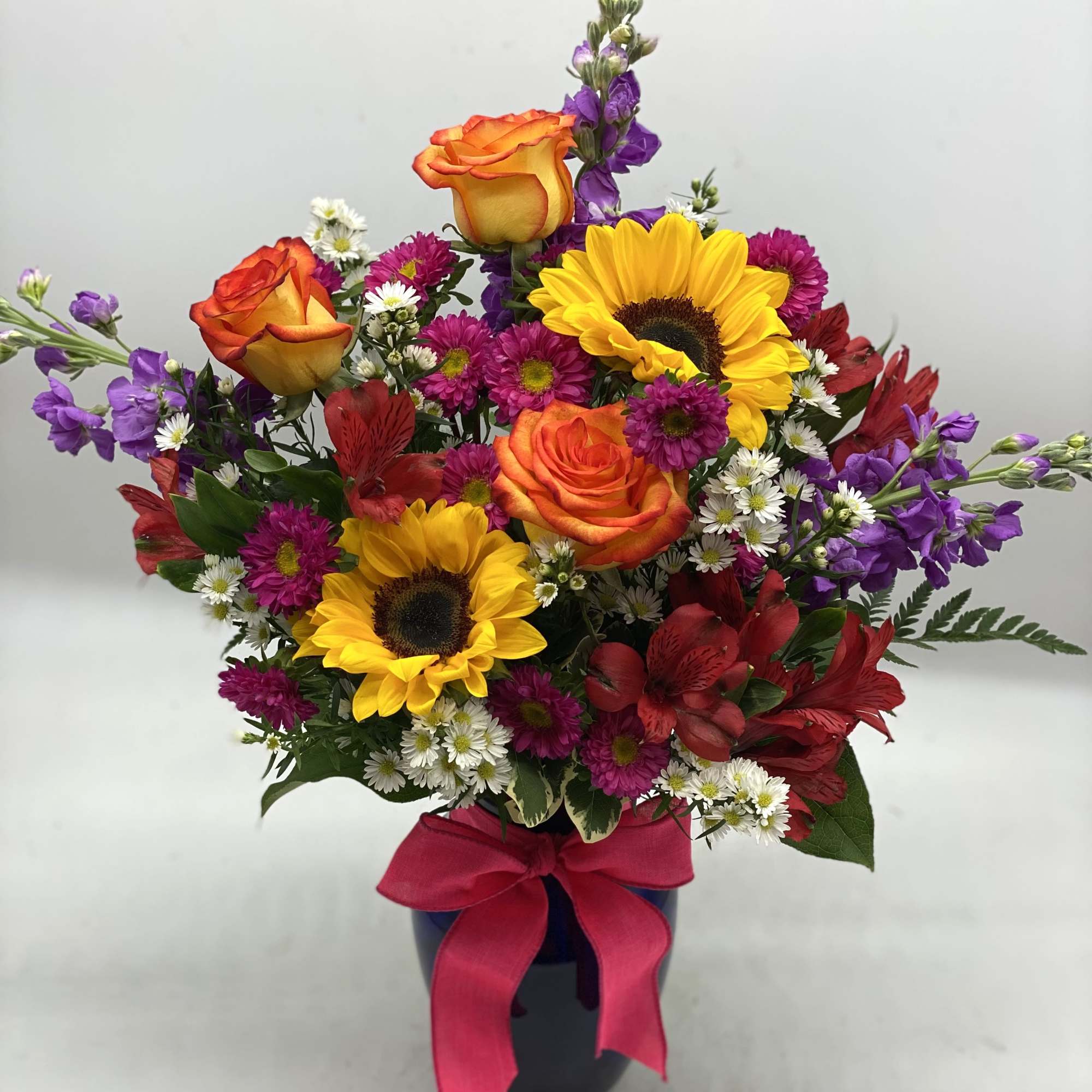 A beautiful, bright mix of fresh flowers designed in a colbalt blue