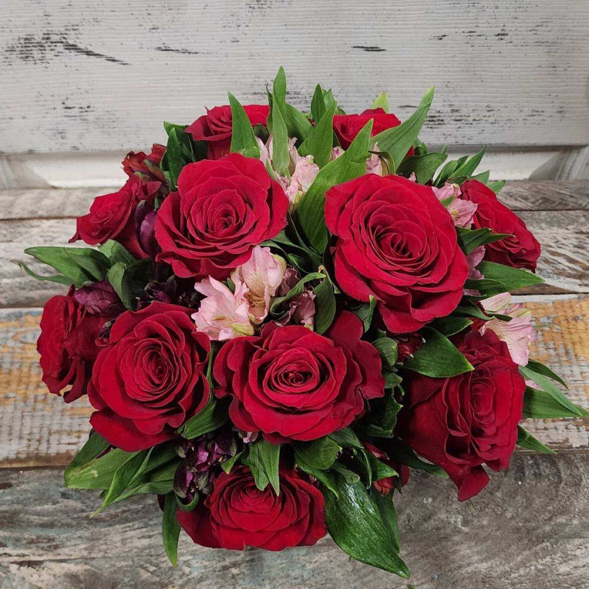 12 beautiful red roses filled together with a colorful verity of alstroemerias