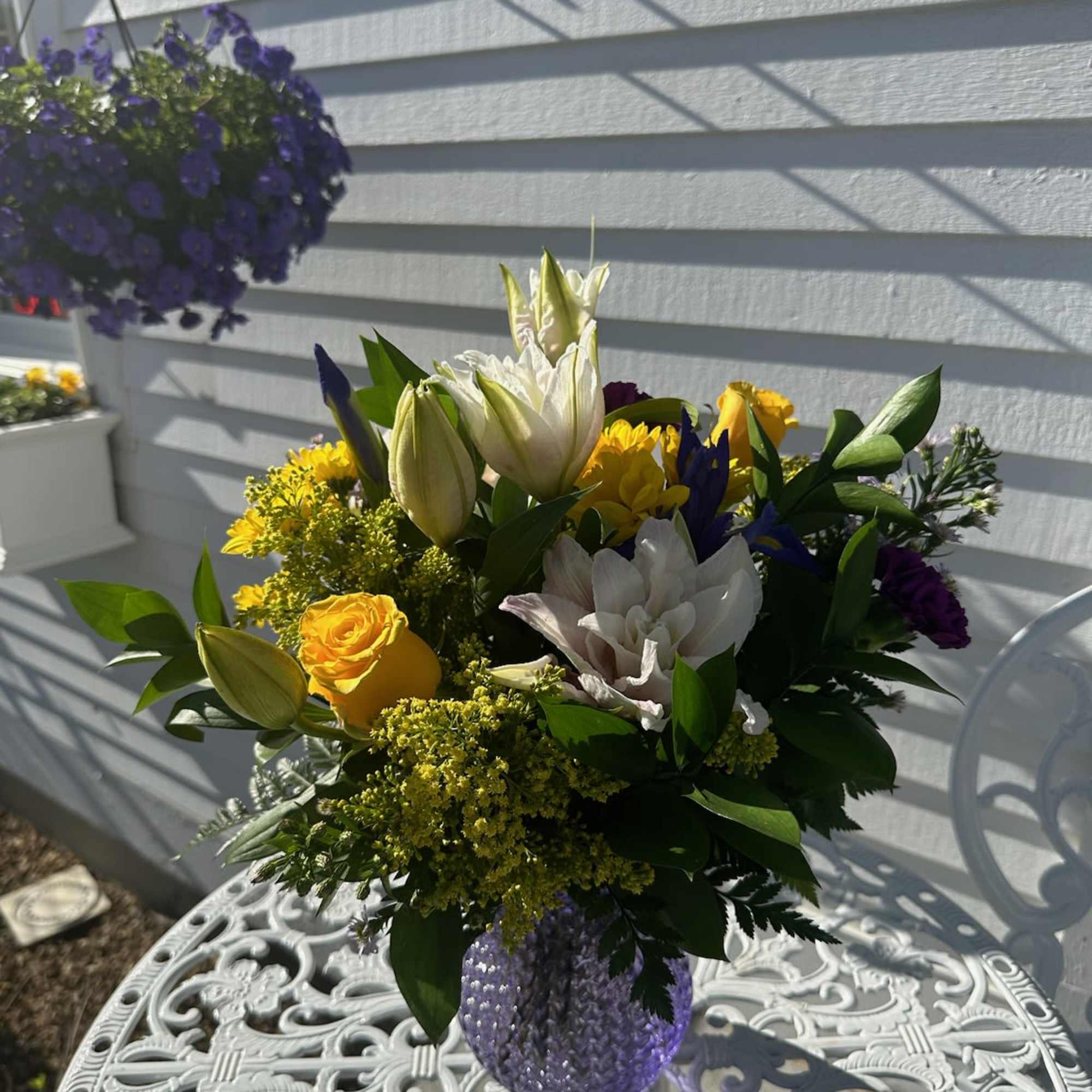 Pink Lilies, Yellow roses, daisies, iris, purple carnations and solidago arranged in Pink Lilies, Yellow roses, daisies, iris, purple carnations and solidago arranged in