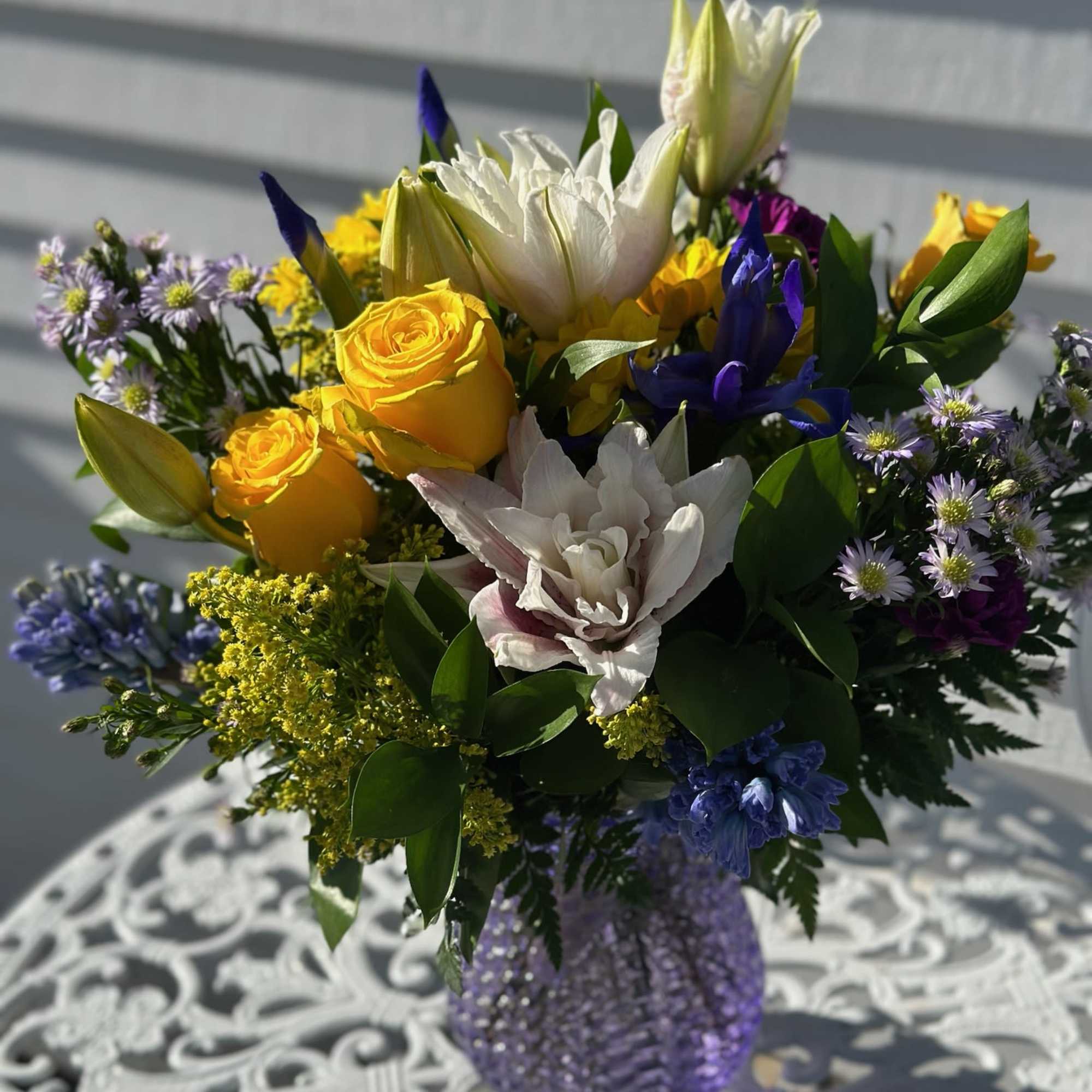 Pink Lilies, Yellow roses, daisies, iris, purple carnations and solidago arranged in Pink Lilies, Yellow roses, daisies, iris, purple carnations and solidago arranged in