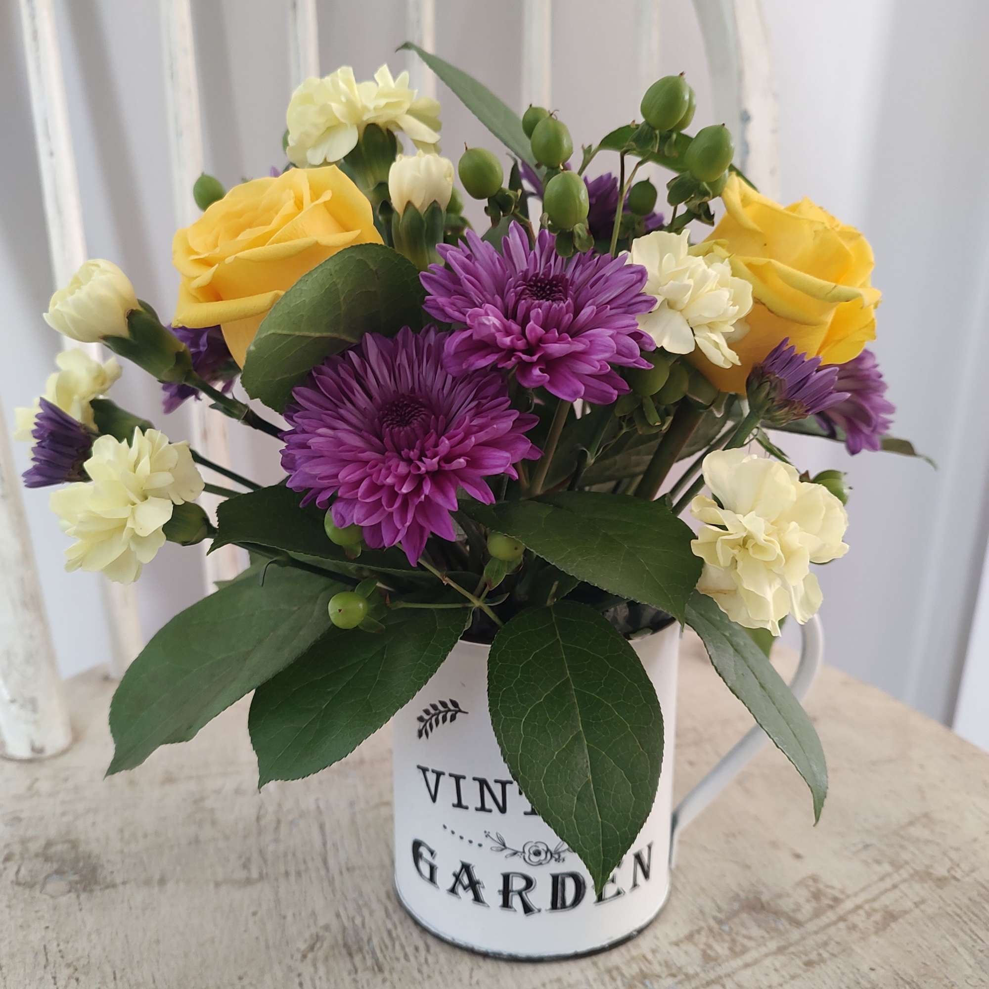 Vintage Garden Cup filled with fresh flowers. Yellows and purple for the
