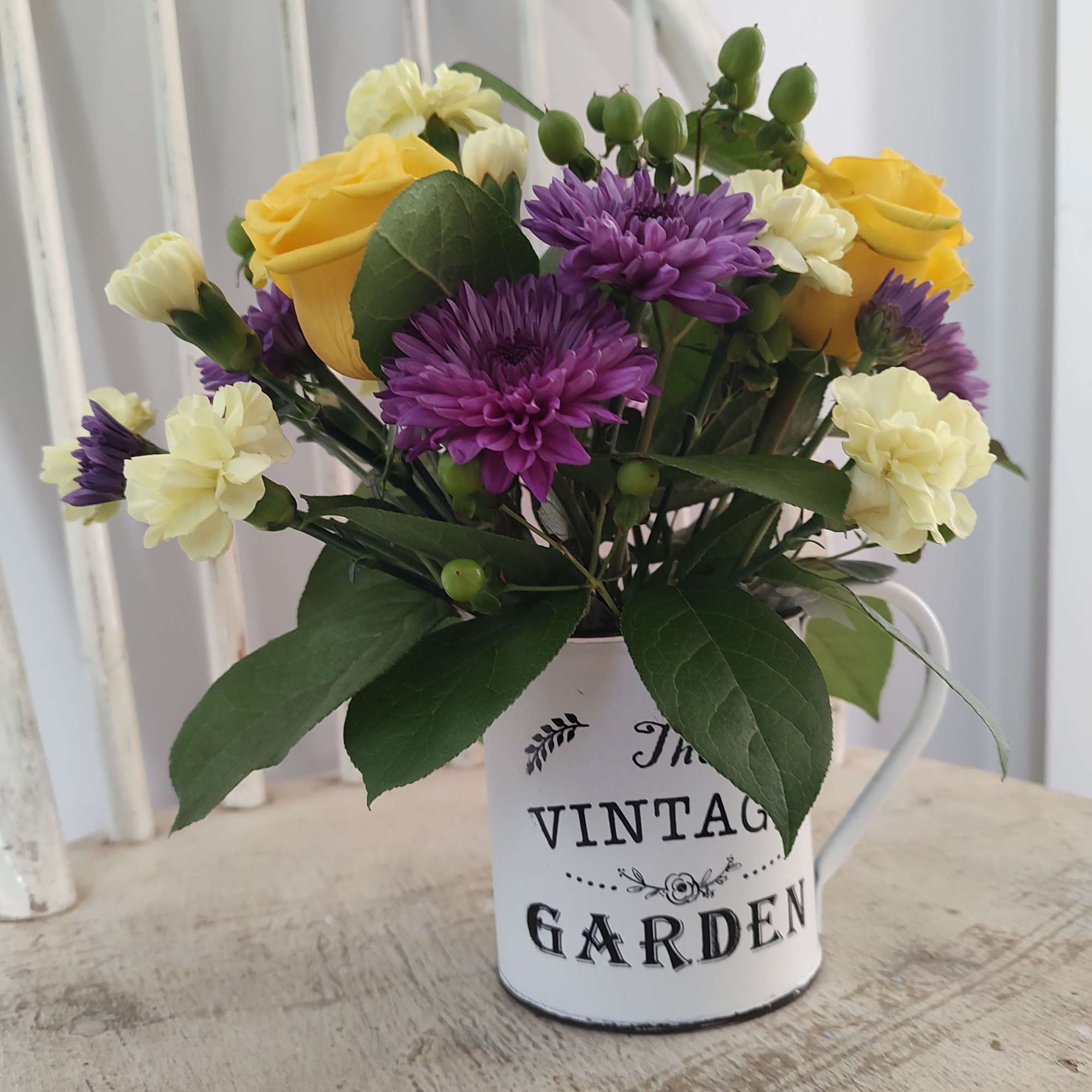 Vintage Garden Cup filled with fresh flowers. Yellows and purple for the