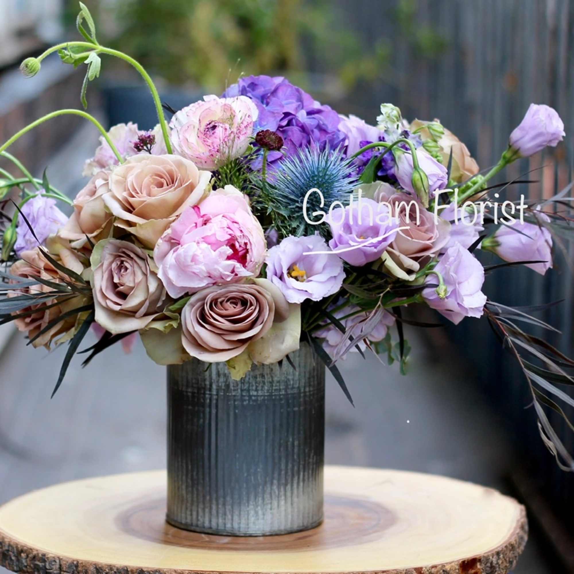 Soft lavender and purple flowers in rustic tin vase. Send unique, gorgeous