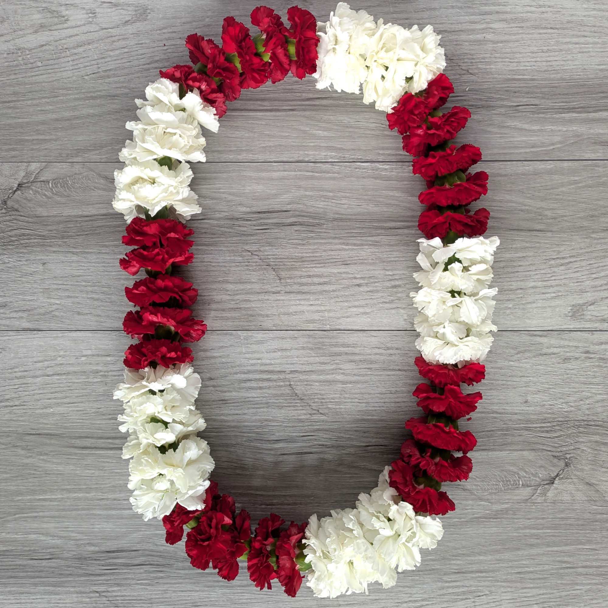 A mix of red and white carnation Lei, perfect for graduation! All