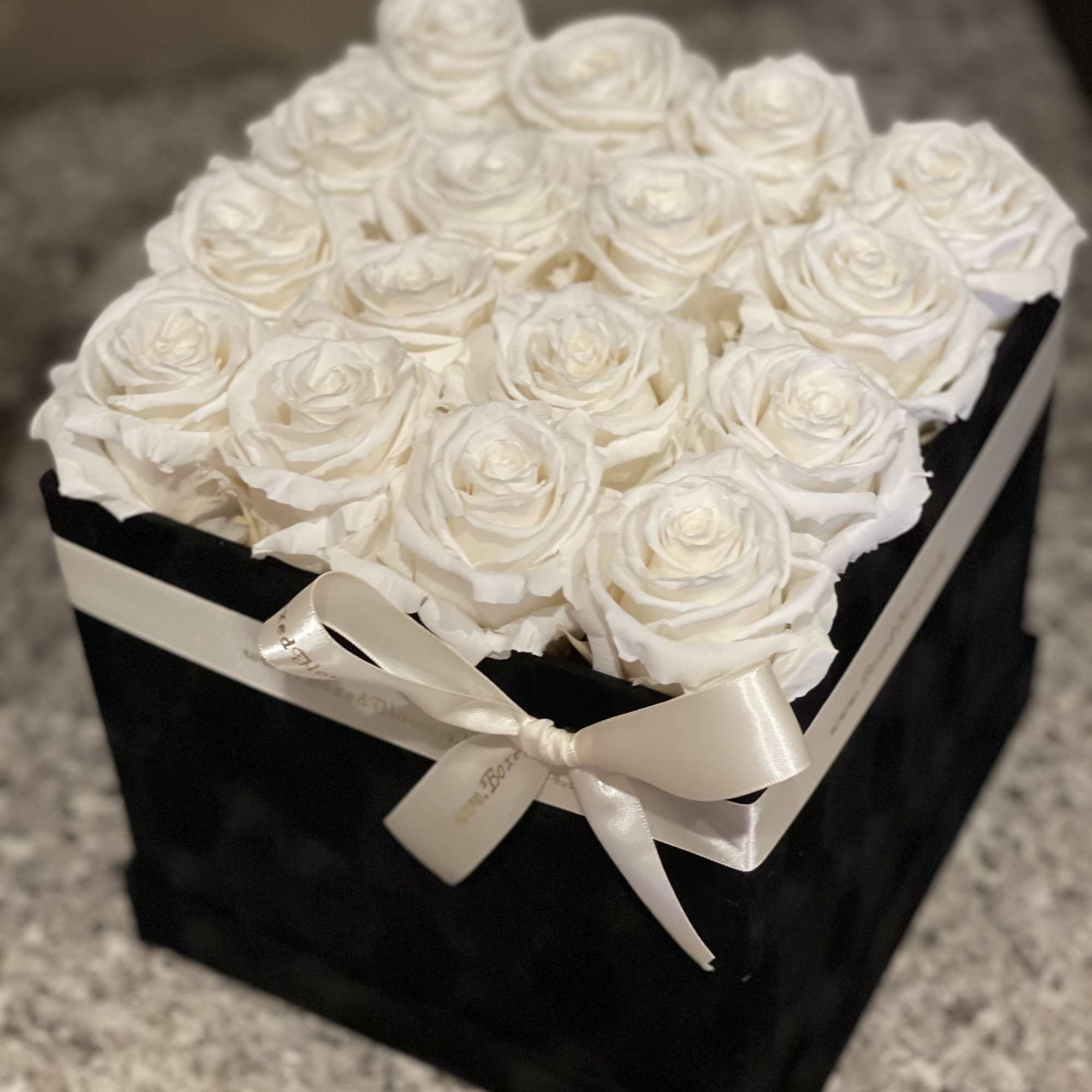 Black square box filled with 16 white everlasting roses. 
You can change Black square box filled with 16 white everlasting roses. 
You can change