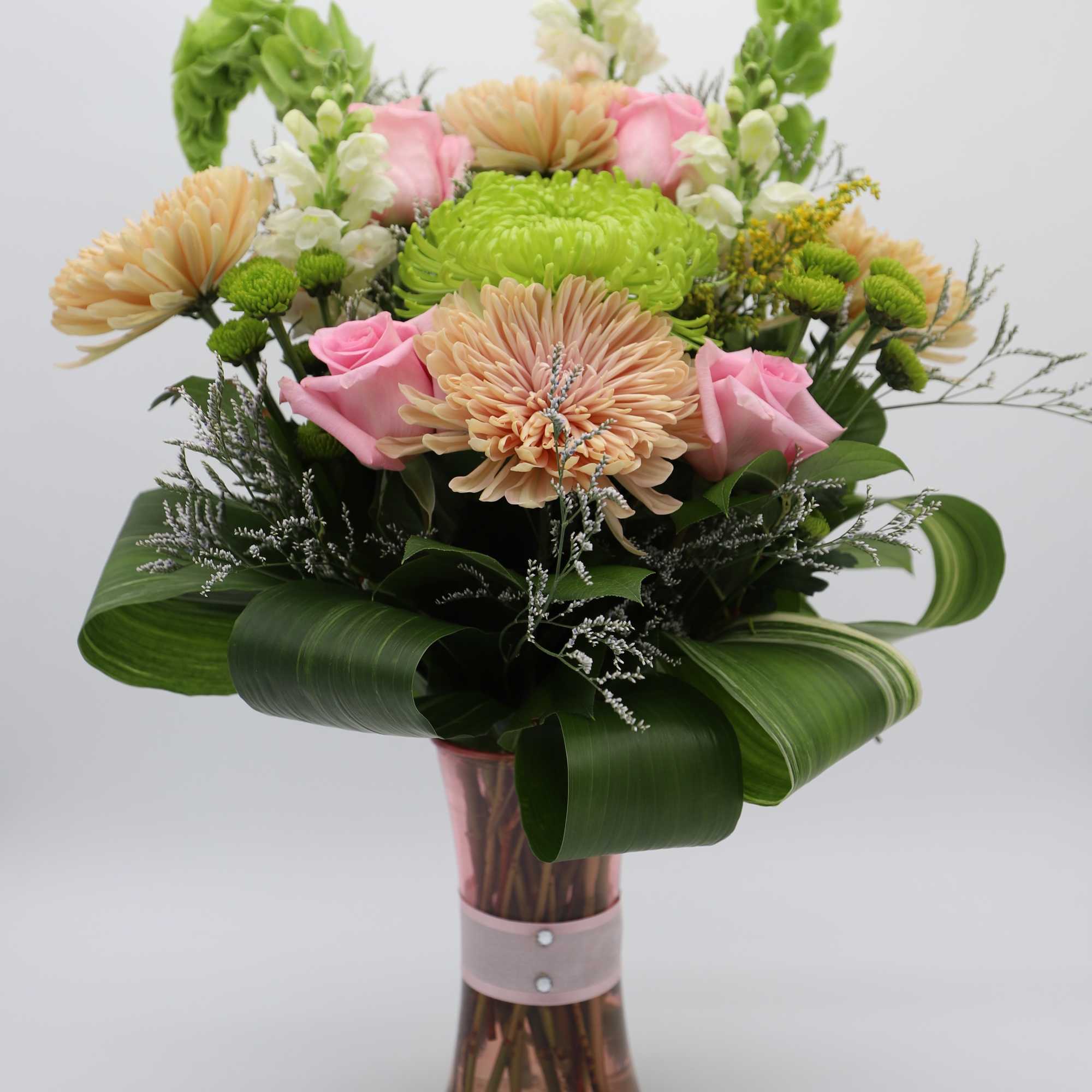 A gorgeous arrangement made with chrysanthemums, roses, button mums, snapdragons, bells of