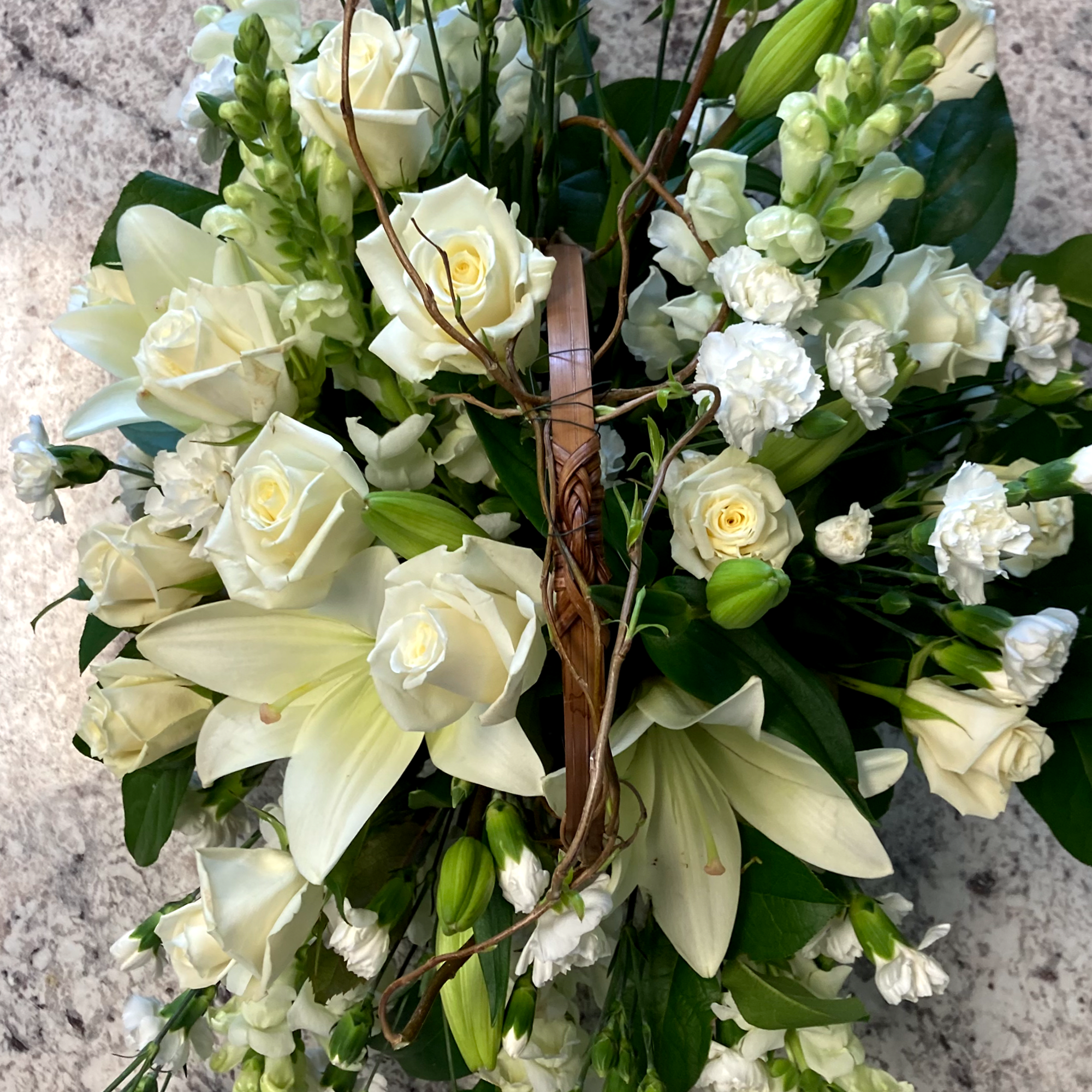 A tranquil mixed arrangement that arrives in a natural wicker basket, showcasing