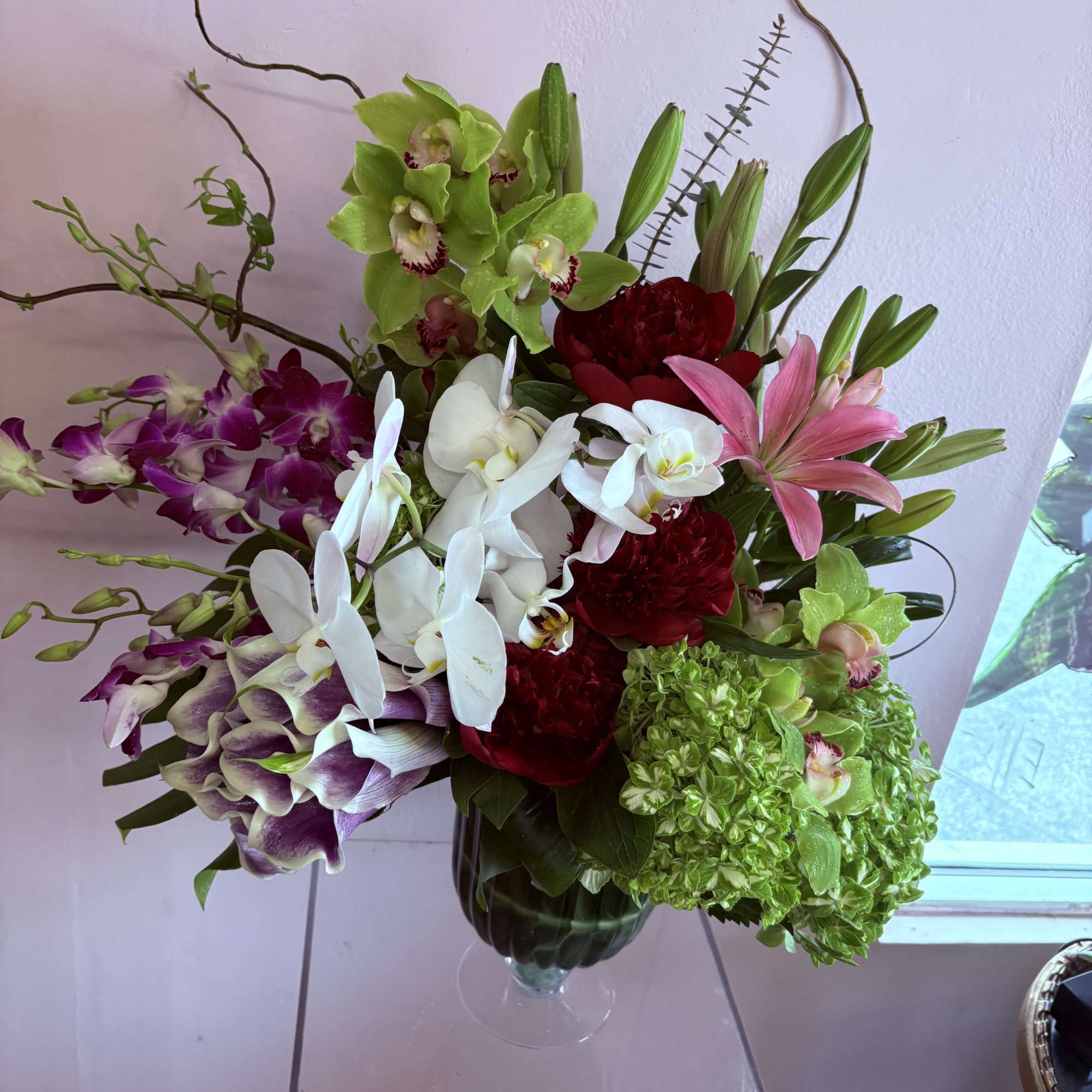 A stunning floral arrangement featuring a variety of orchids - Pink bom