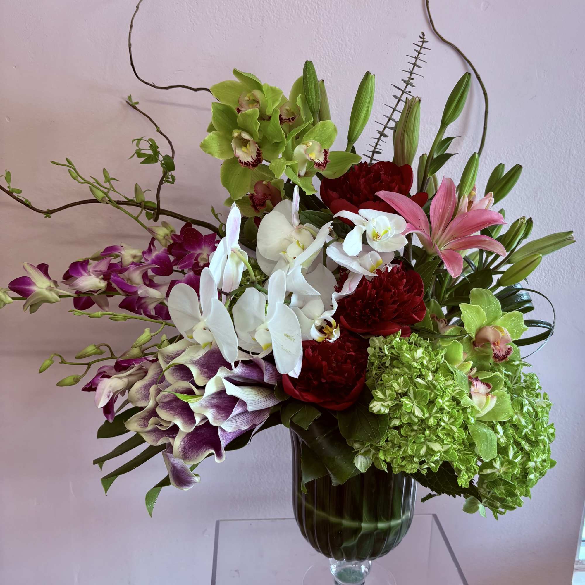 A stunning floral arrangement featuring a variety of orchids - Pink bom