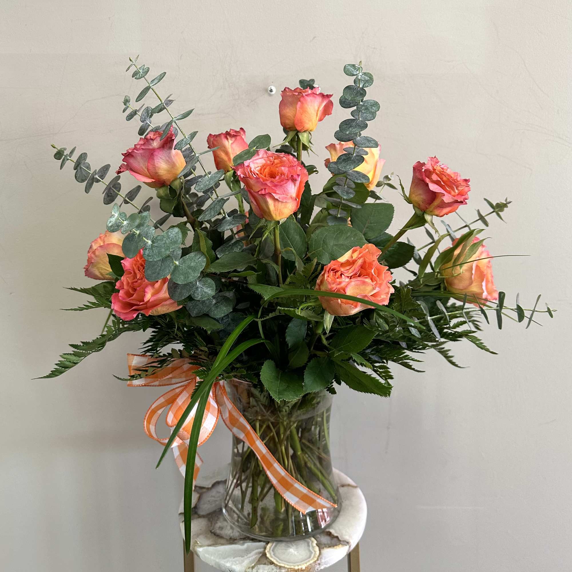 A dozen free spirit roses with spiral eucalyptus in a clear glass A dozen free spirit roses with spiral eucalyptus in a clear glass
