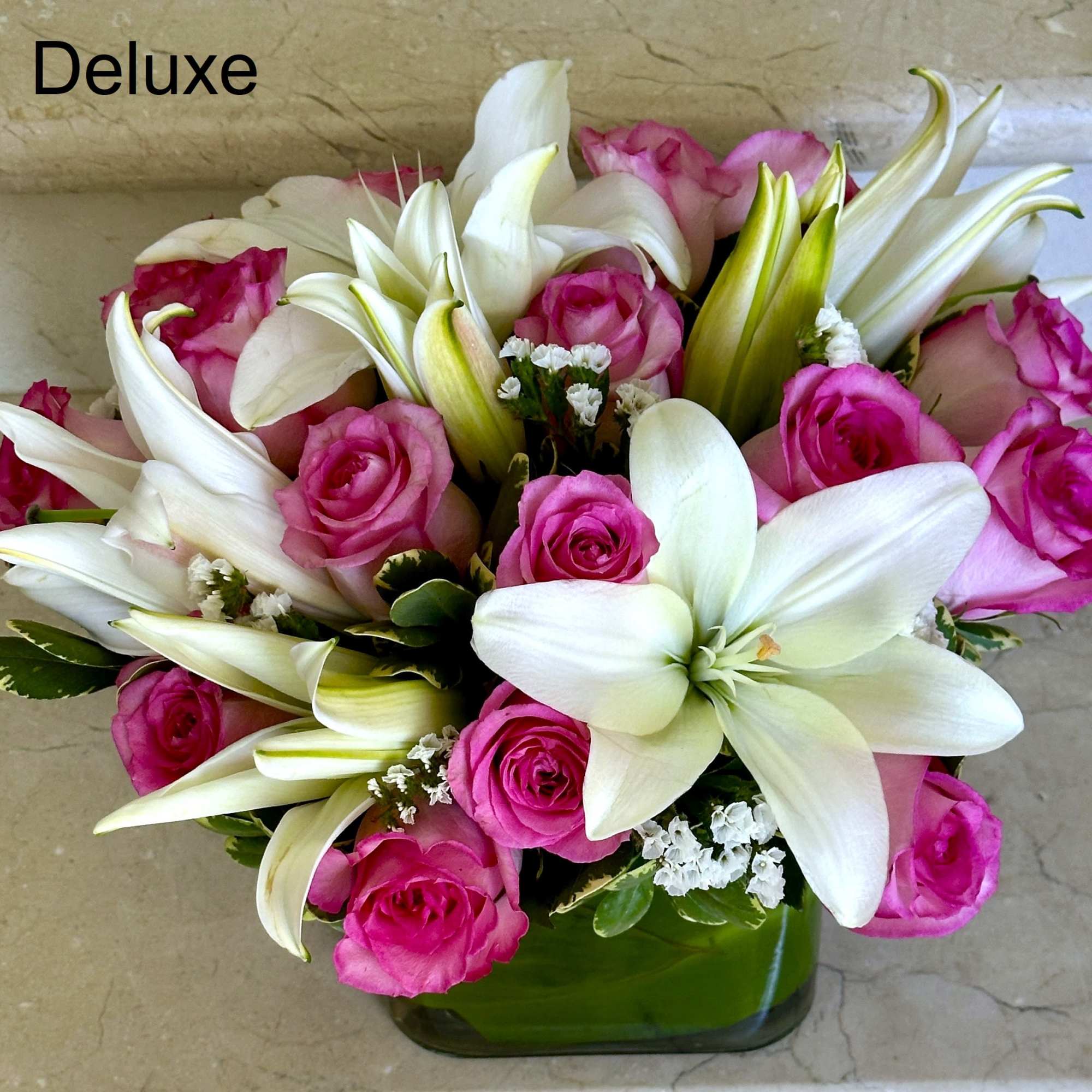 White Lilies and 12 Pink Roses with greens arranged in a glass White Lilies and 12 Pink Roses with greens arranged in a glass