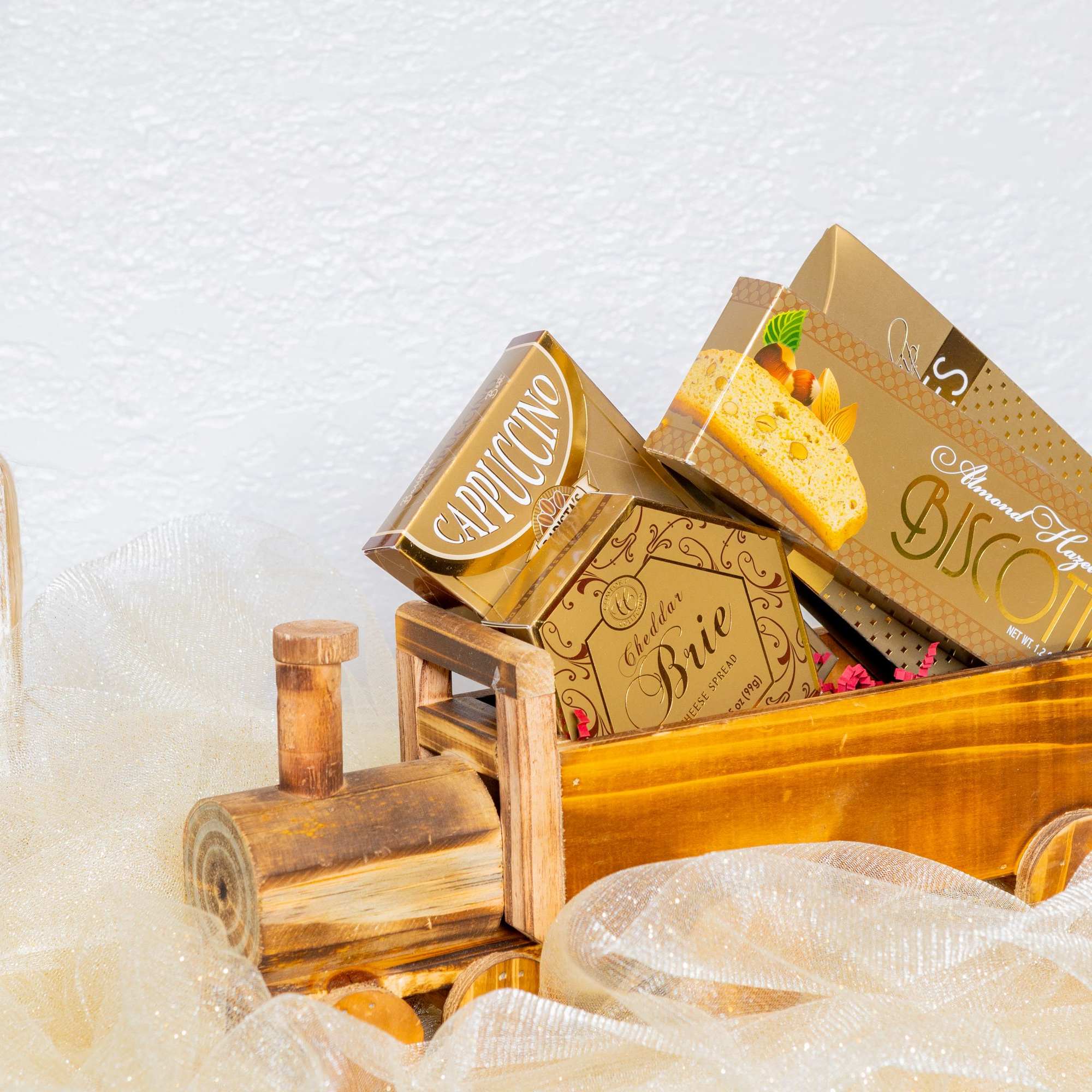 A charming wooden train filled with gourmet treasures, including biscotti, cheese spread